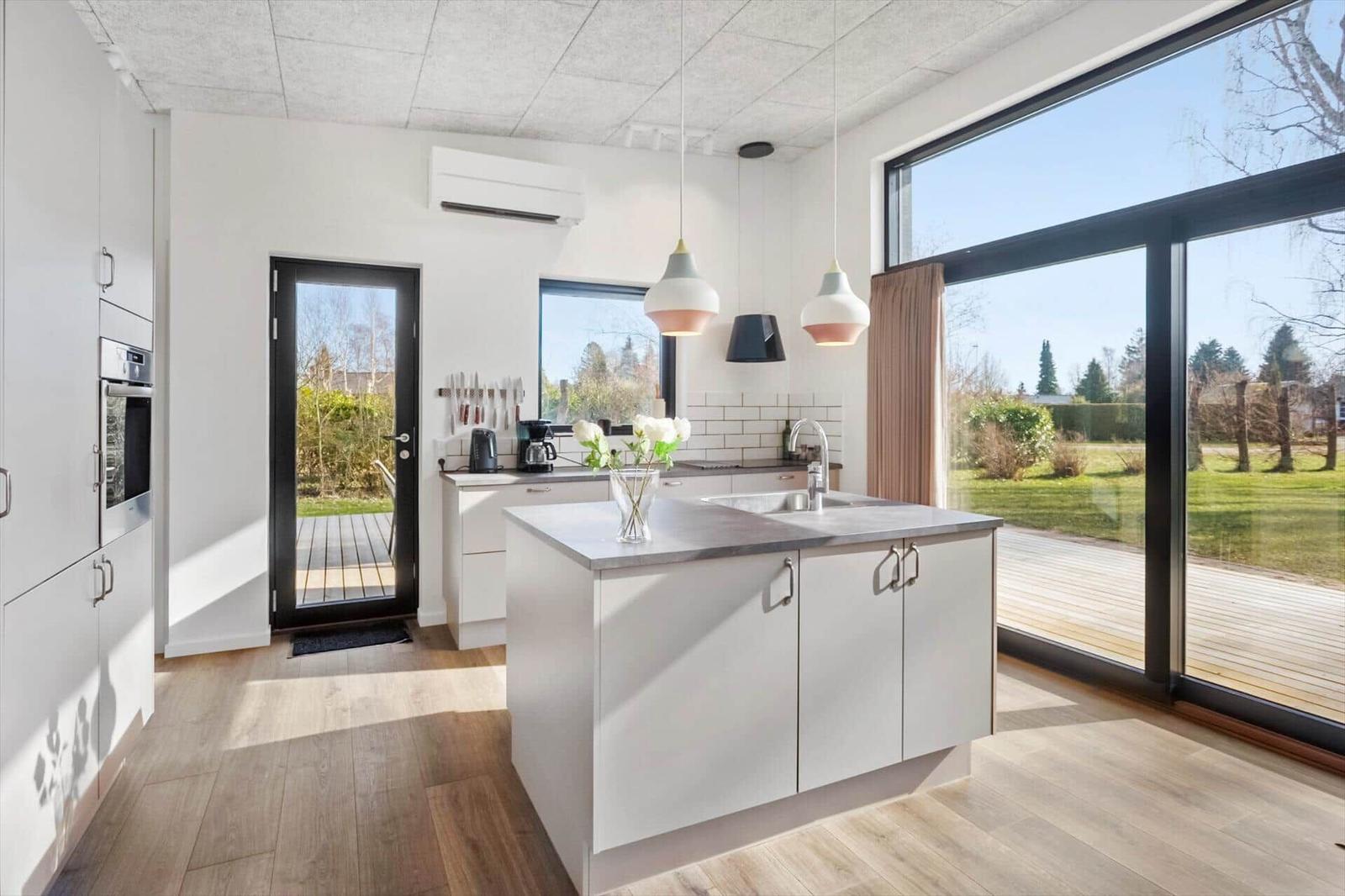 Kitchen with island, large windows, and view of the terrace.