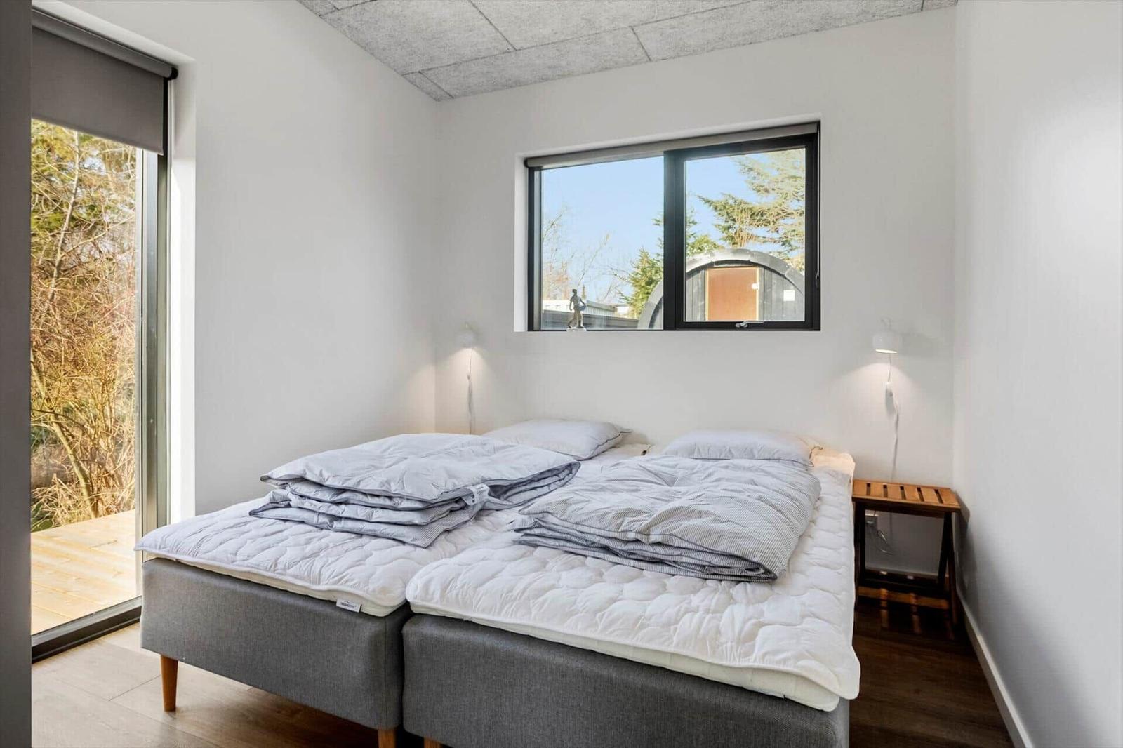 Bedroom with two mattresses, windows, and door to balcony.