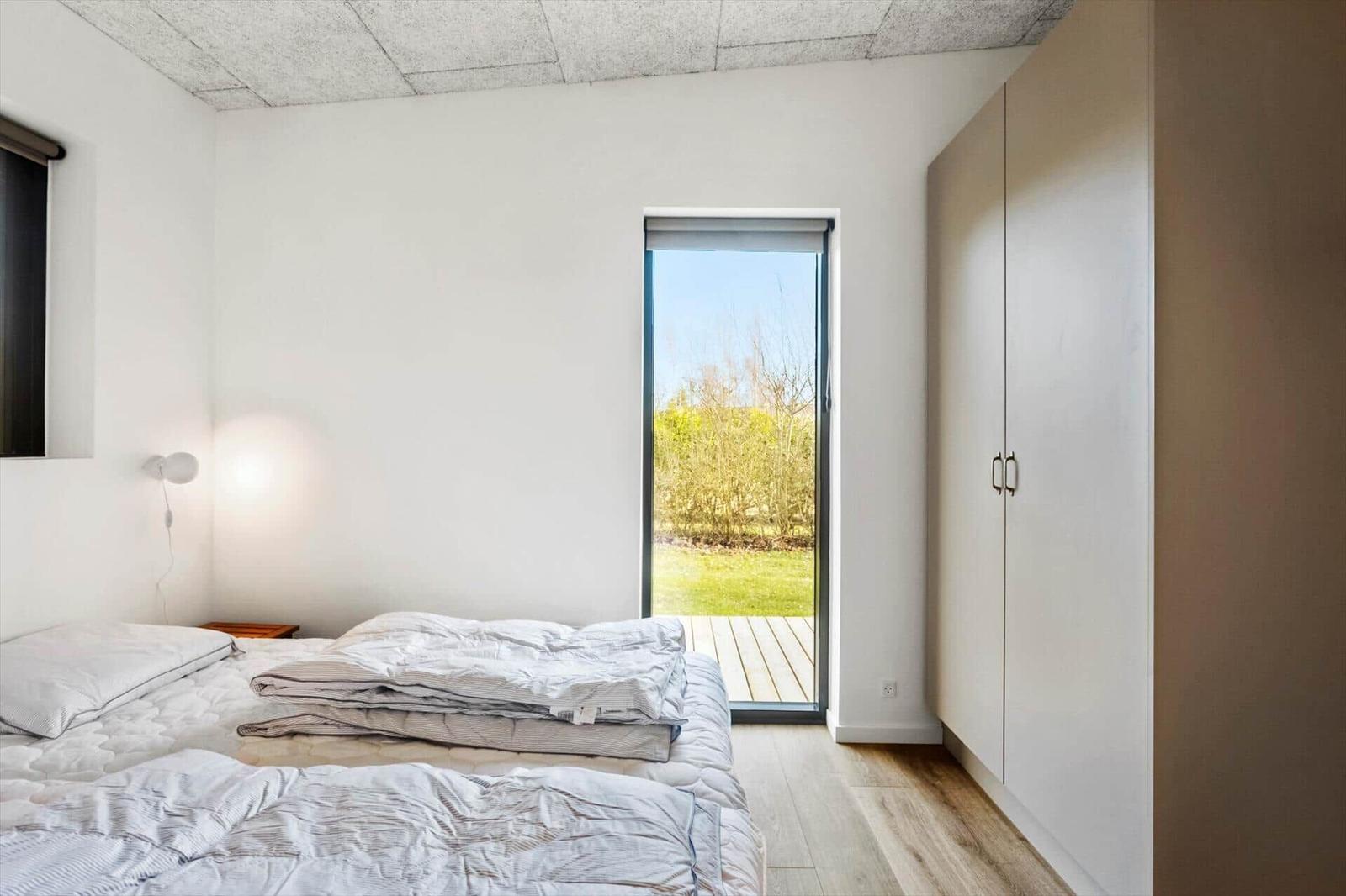 Bedroom with bed, wardrobe, and door to a terrace.