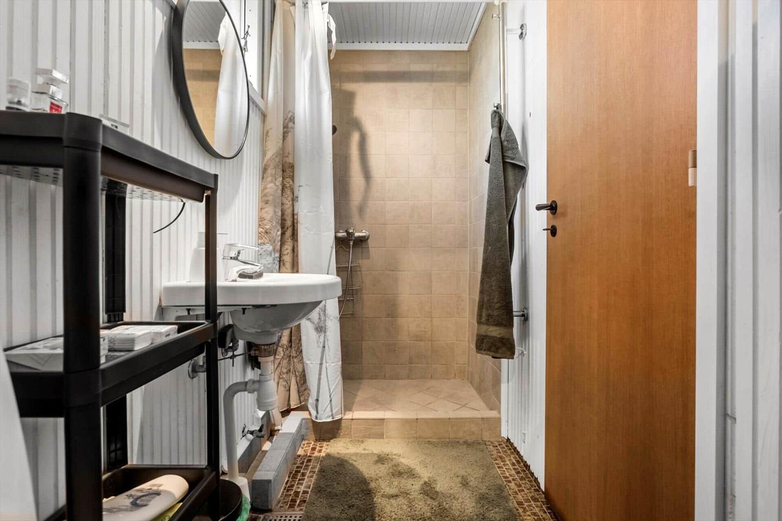 Bathroom with shower, sink, and mirror.