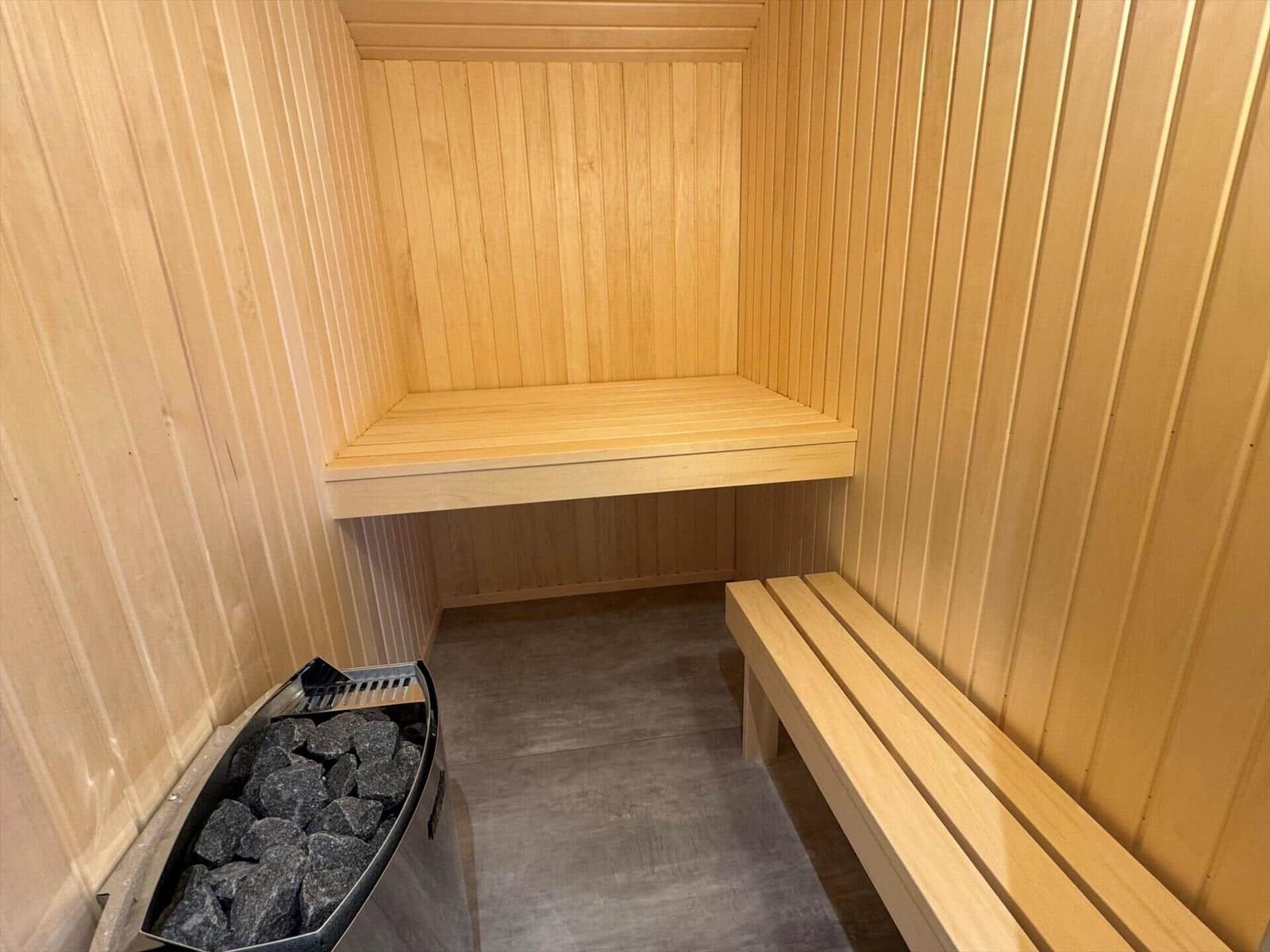 Sauna with wooden bench and stone bin