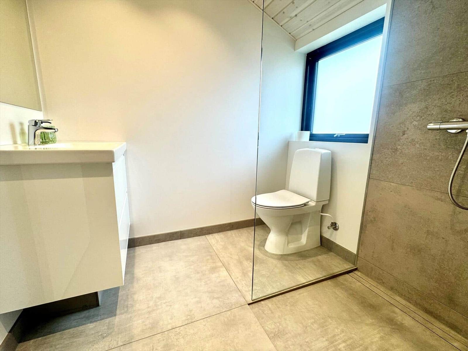 Bathroom with toilet, shower, and sink.