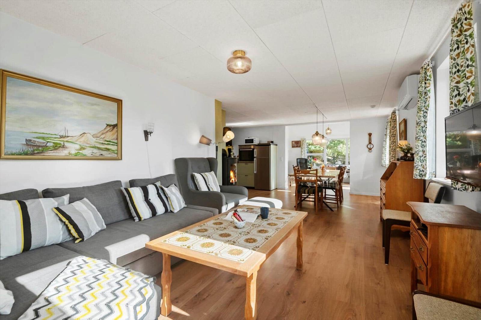 Wohn- und Essbereich mit Sofa, Couchtisch und Küchenbereich im Hintergrund.