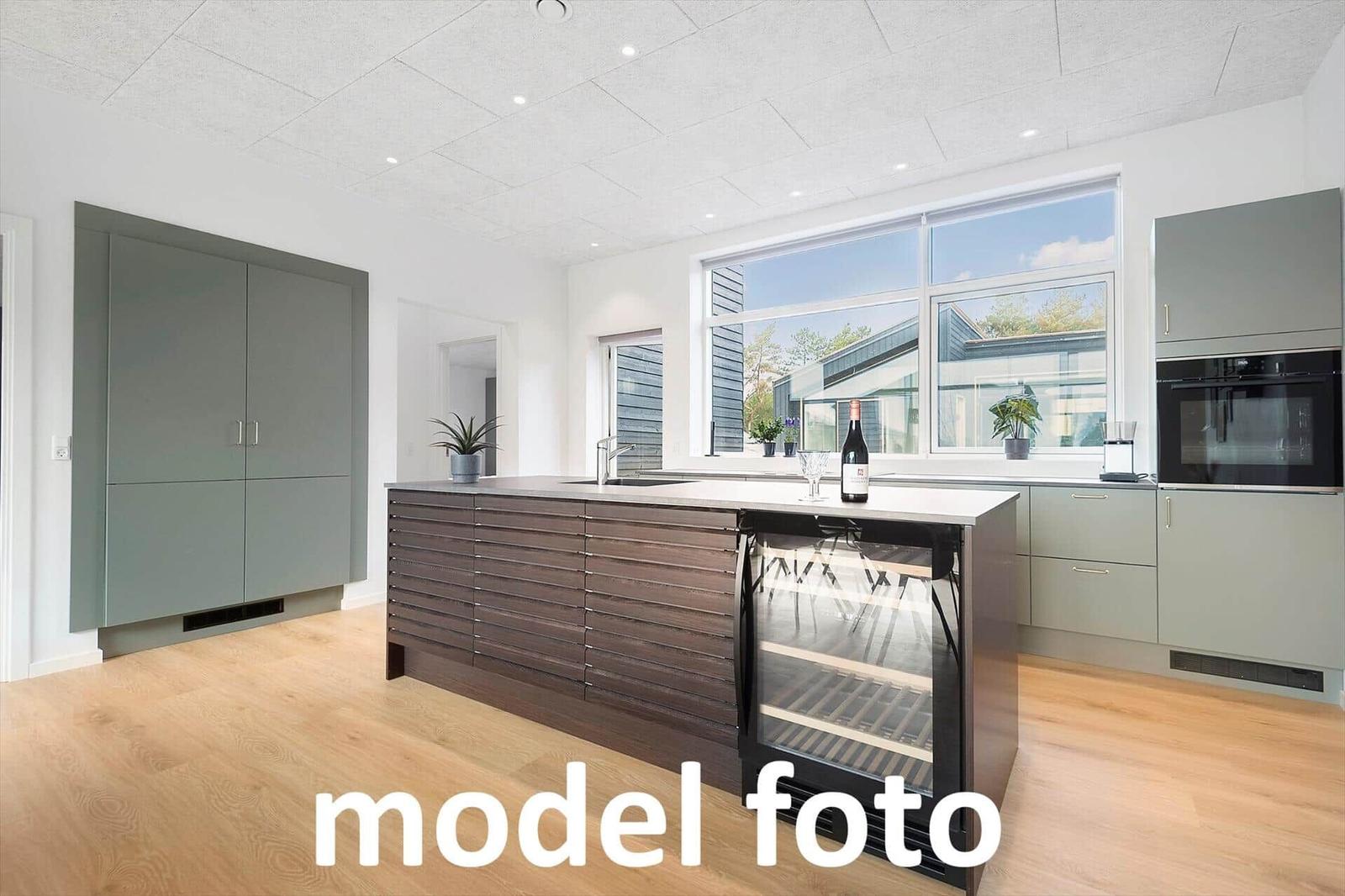 Moderne Küche mit Kücheninsel, integriertem Kühlschrank und großen Fenstern.
