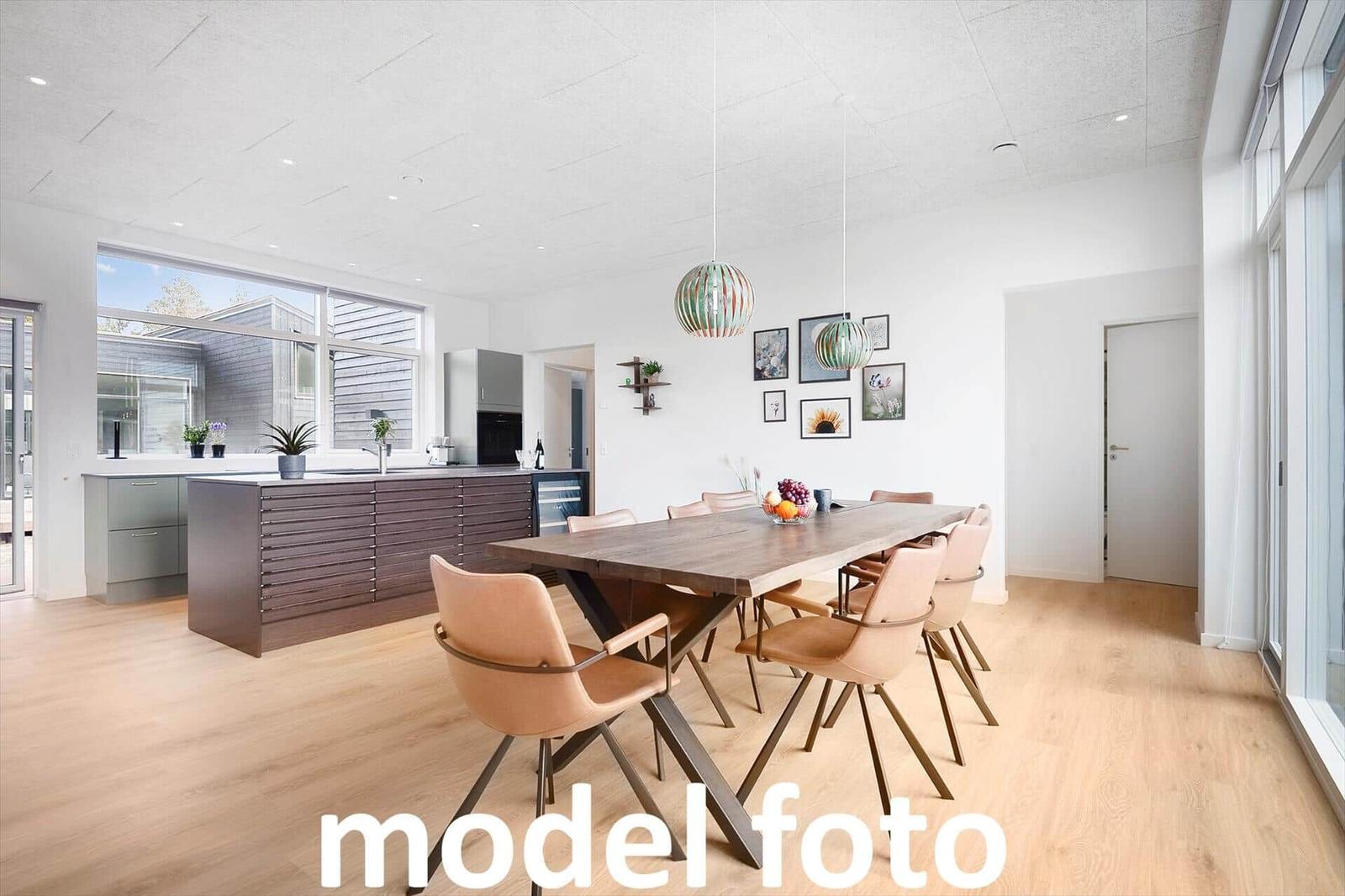 Moderne Küche mit Essbereich und großem Fenster. Holzboden und hängende Lampen.