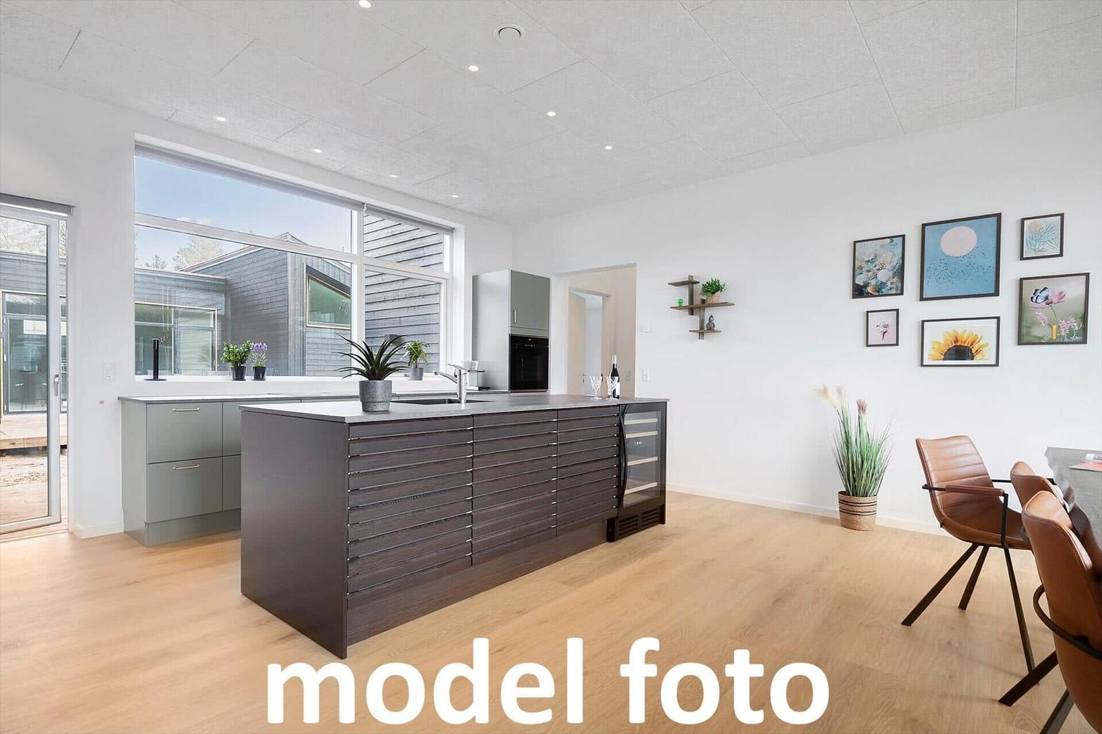 Moderne Küche mit Kücheninsel und Essbereich. Große Fenster und Holzboden.