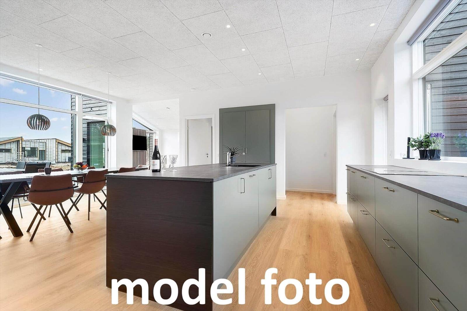 Moderne Küche mit Kücheninsel und Essbereich. Holzboden und große Fenster.