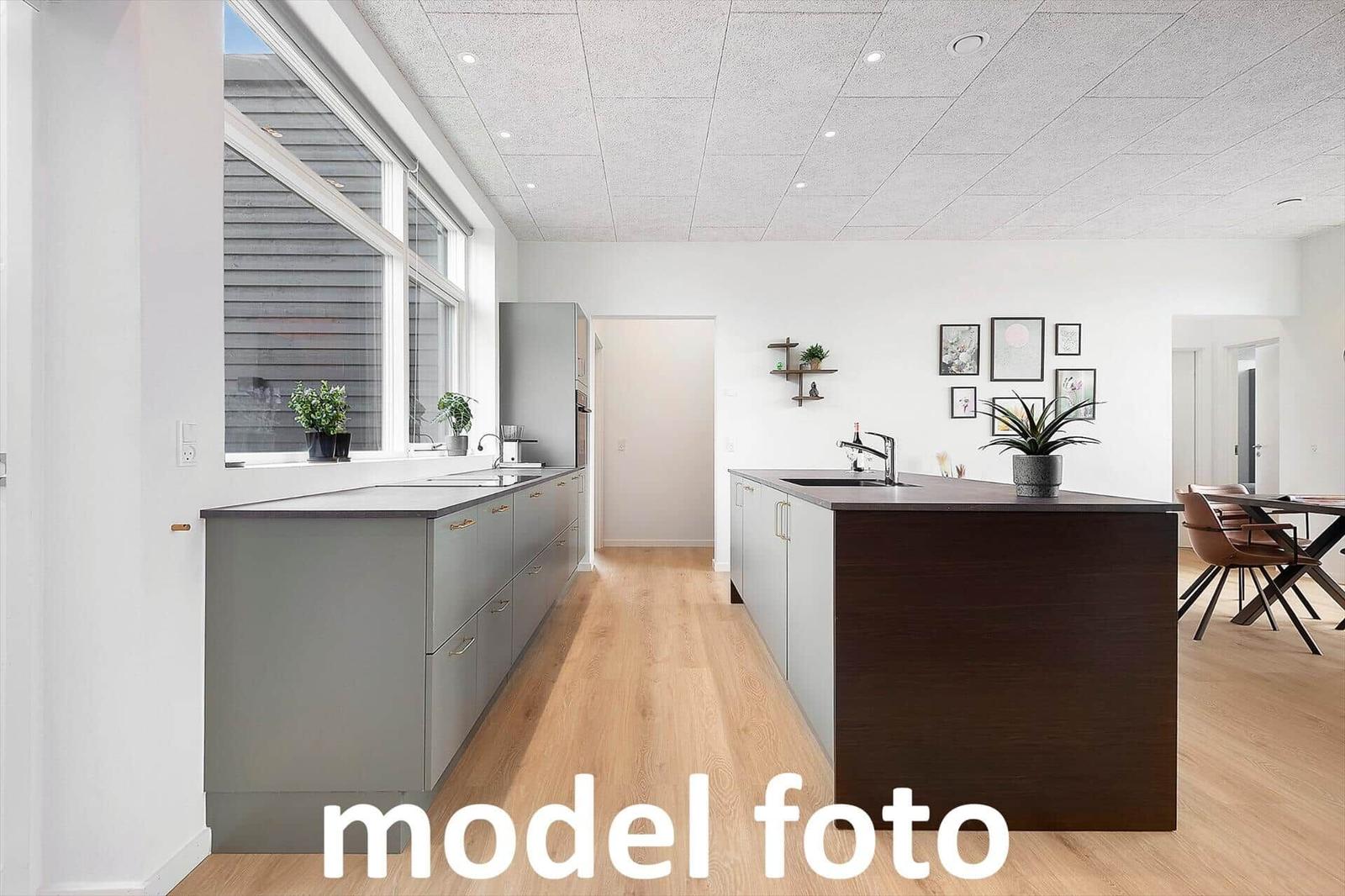 Moderne Küche mit Kücheninsel und Holzboden. Große Fenster und Wanddekoration.