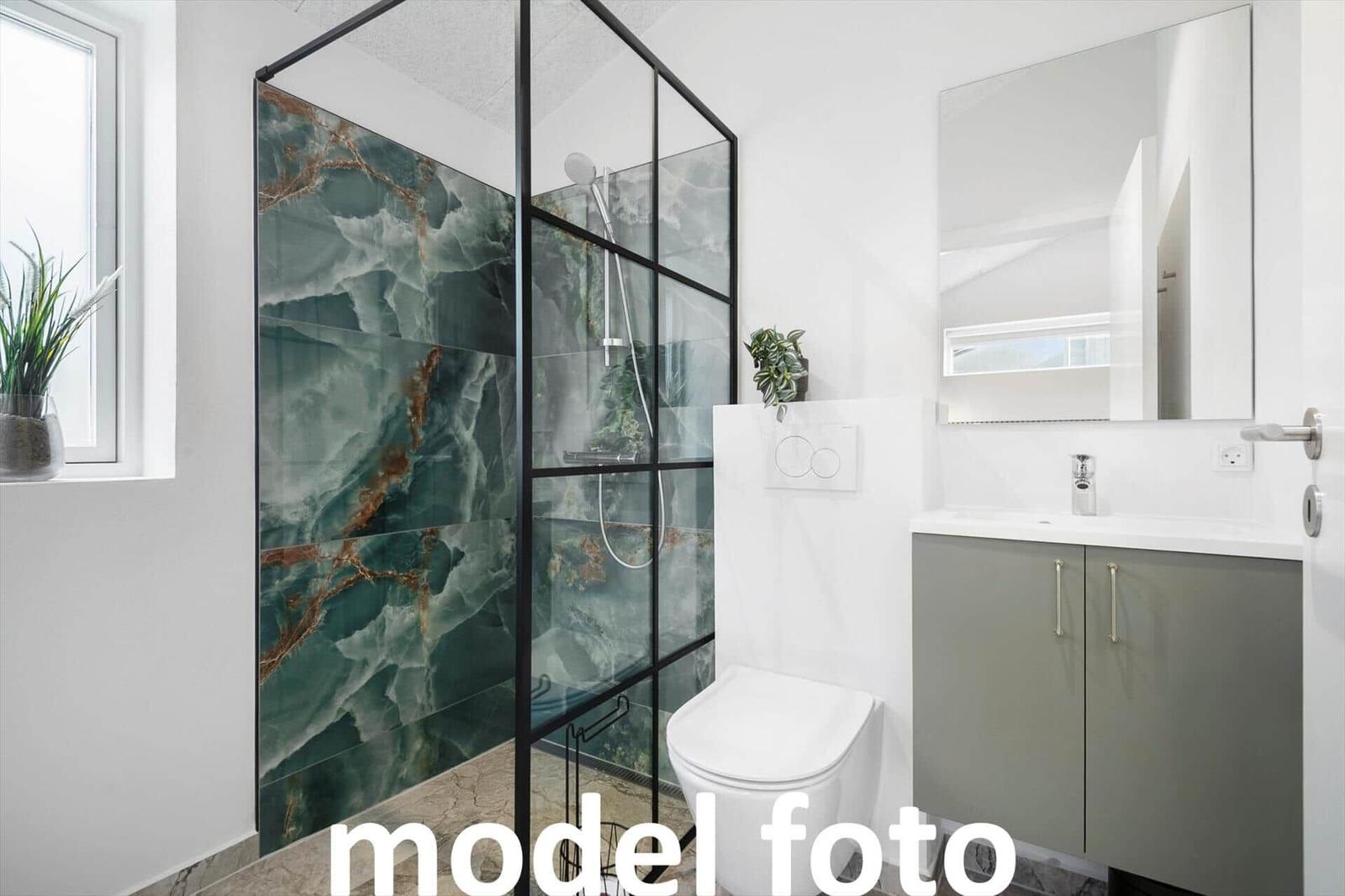 Bad mit Dusche, Waschbecken und Toilette. Duschwand mit Marmoroptik.