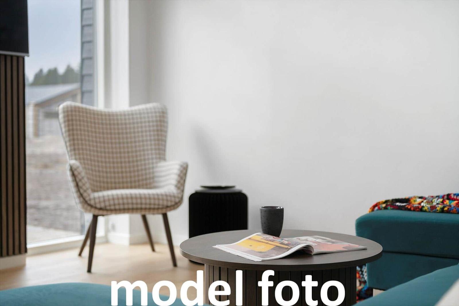 Ein Wohnbereich mit Sessel, Tisch und Zeitschrift.