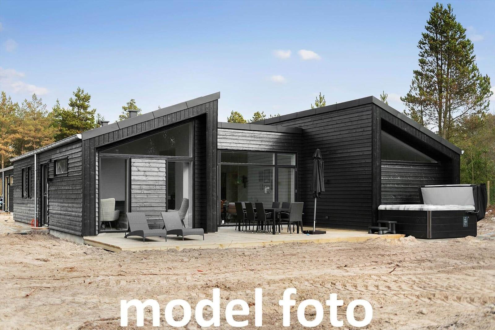 Moderne Holzhütte mit Terrasse, Sitzgelegenheiten und Whirlpool im Wald.