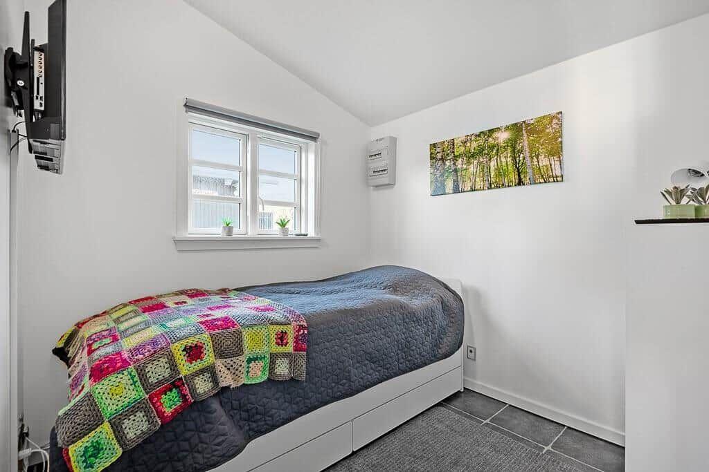 Schlafzimmer mit Bett, Fenster, Wandbild und TV
