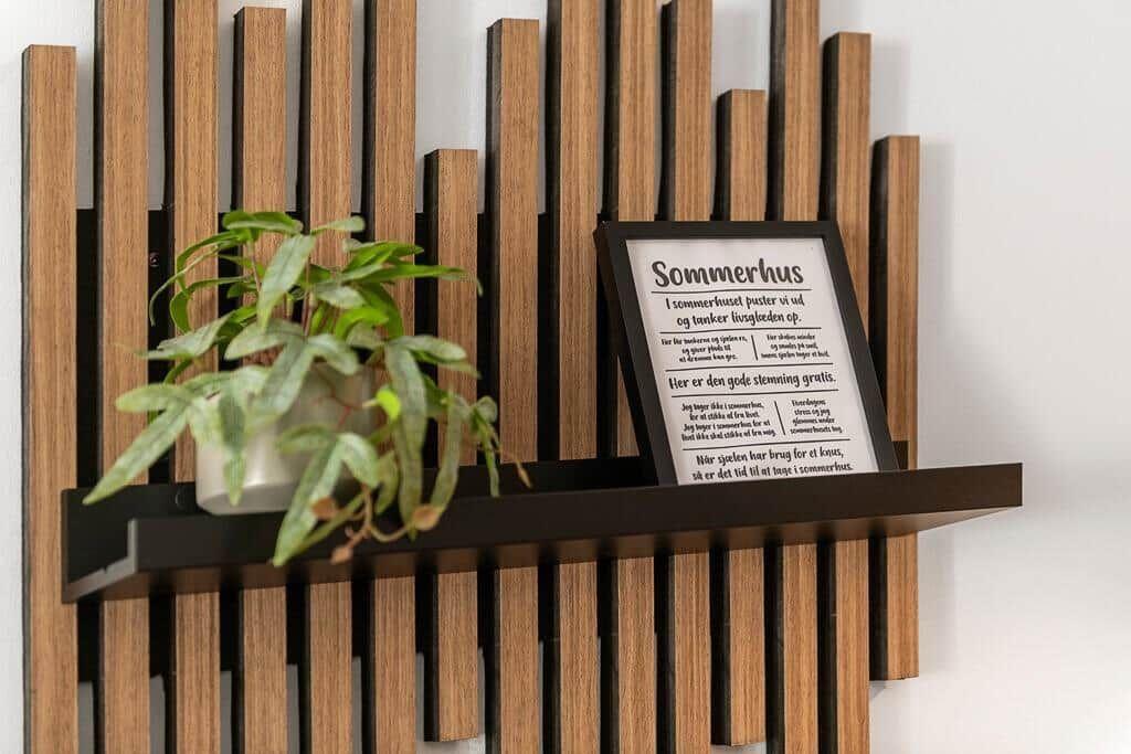 Wandregal mit Pflanze und gerahmtem Text an der Wand.