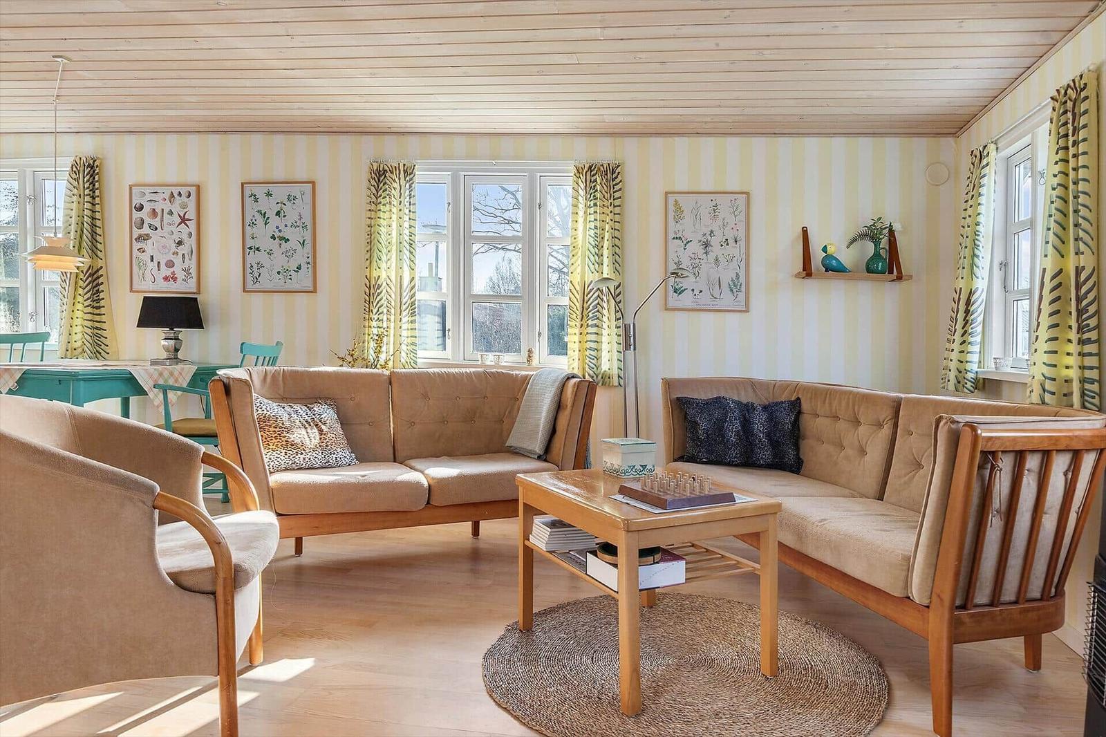 Wohnzimmer mit zwei Sofa, Tisch und Wandbildern.