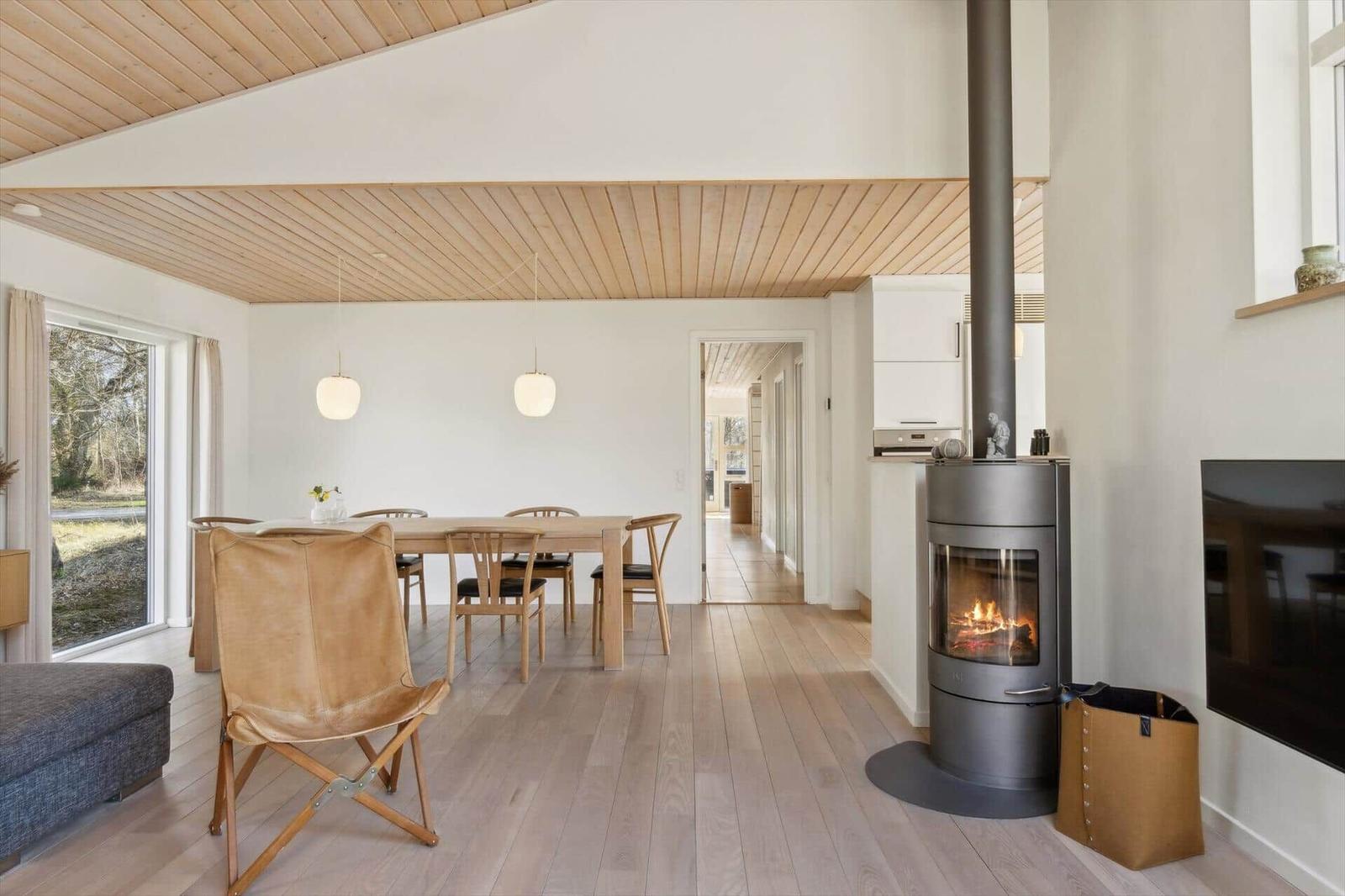 Wohn- und Essbereich mit Holzfußboden, Kamin und Essgruppe.