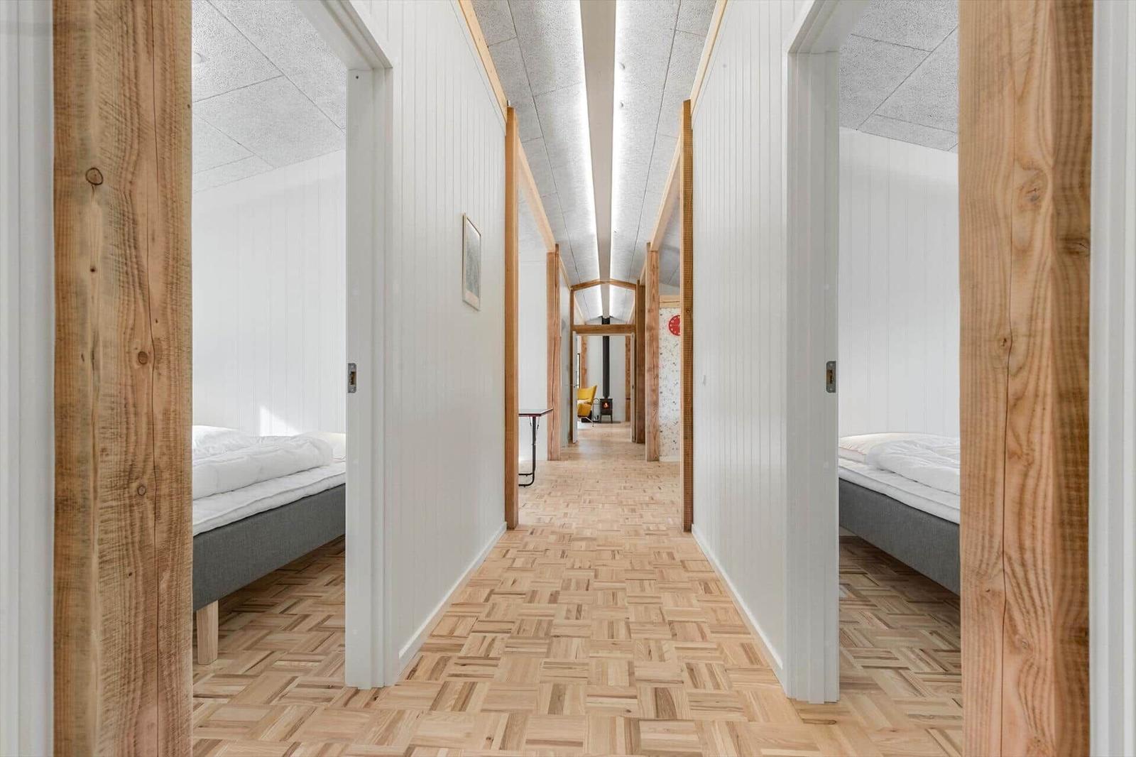 Long hallway with bedrooms and wooden floor