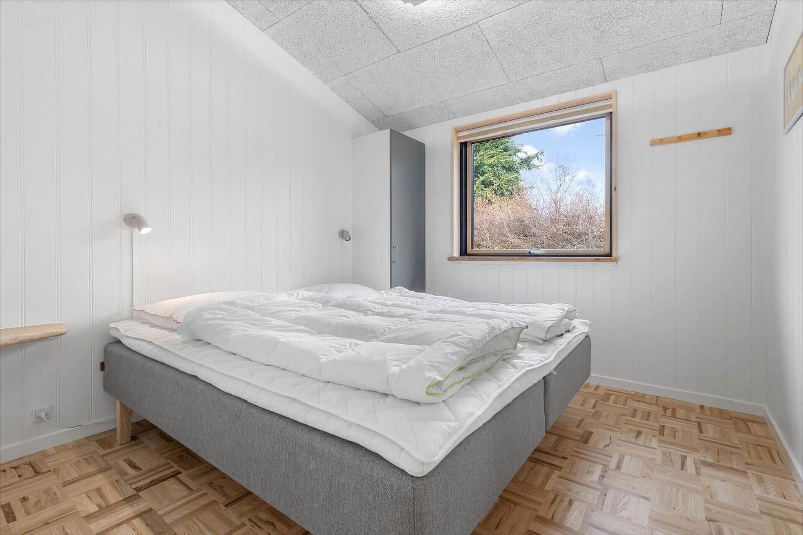 Bedroom with bed, window, and wooden floor