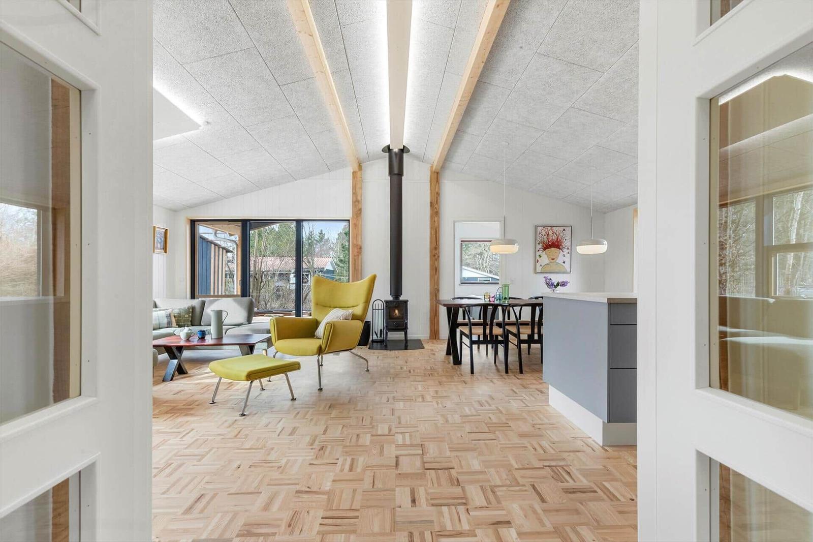 Living and dining area with wooden floor, fireplace, and seating.