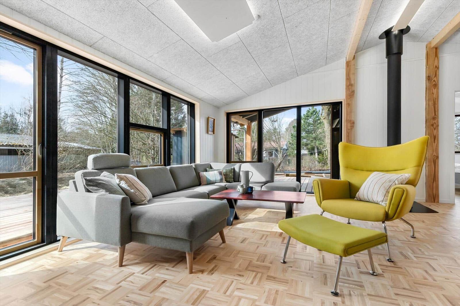 Living room with gray sofa, yellow chair, and wooden floor.