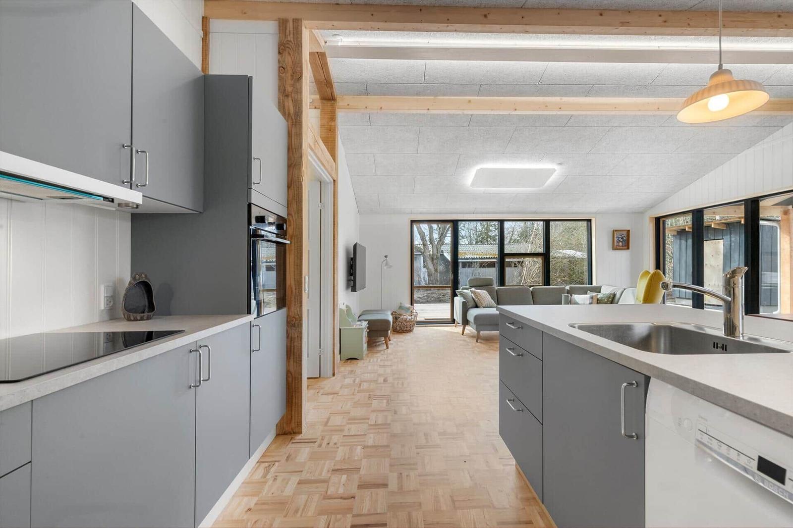 Kitchen with countertop and dining area with sofa and windows.