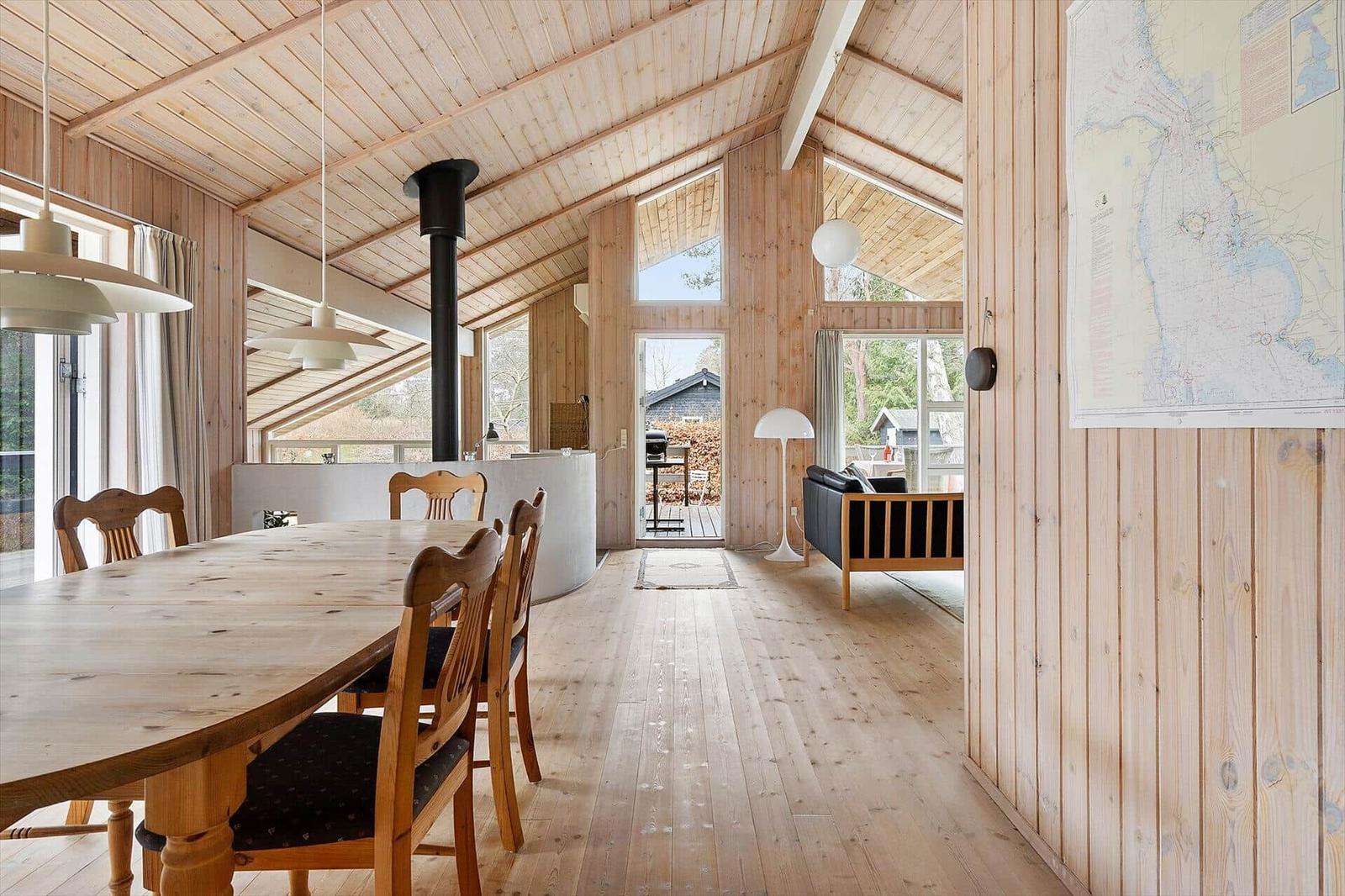 Wooden house with dining area, living area, and fireplace.