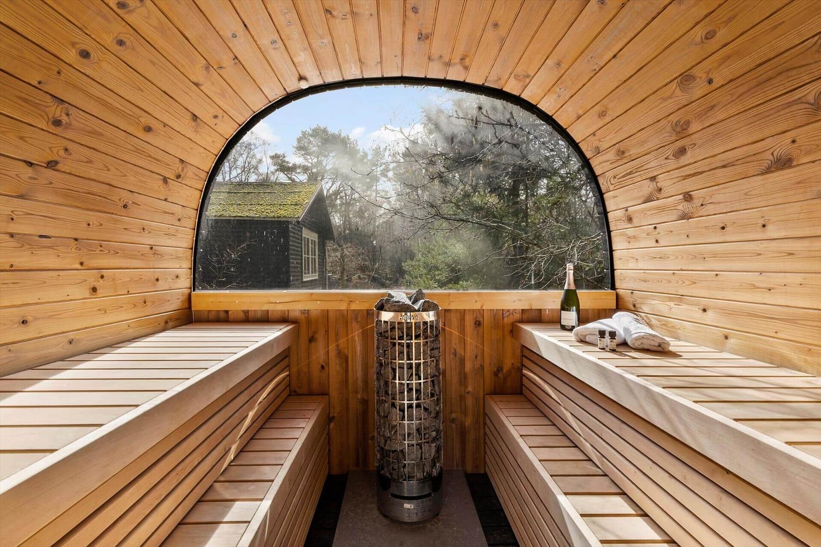 Sauna with wooden benches and round window view of forest