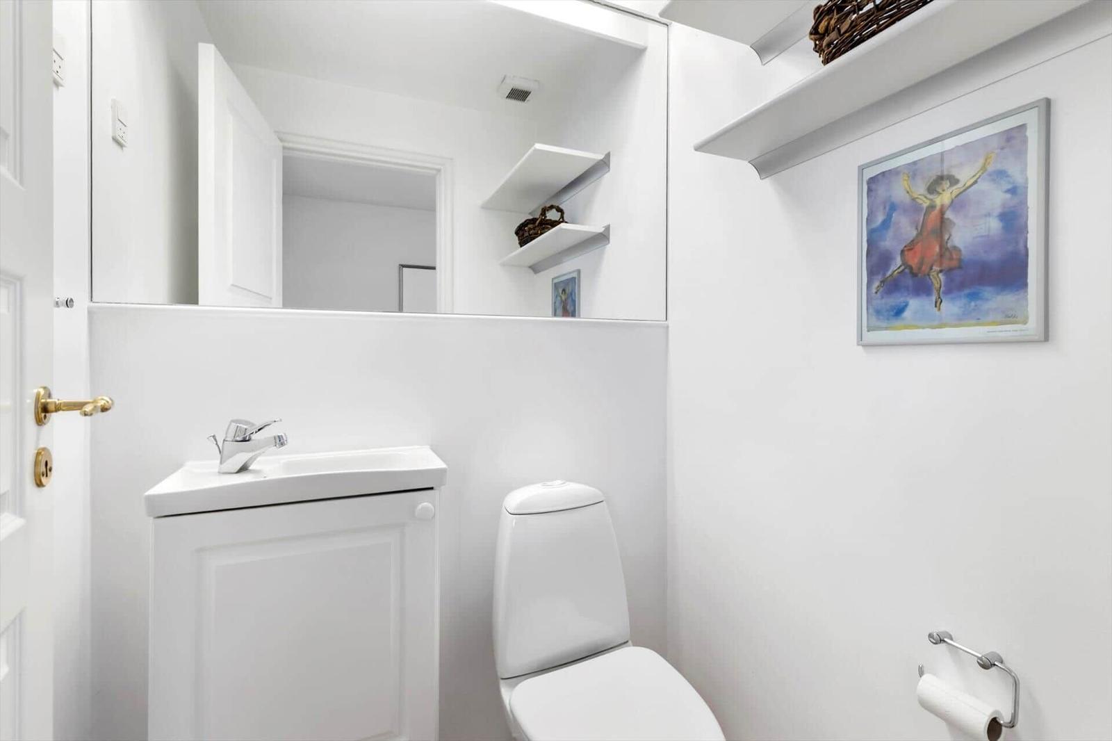 Bathroom with toilet, sink, and mirror