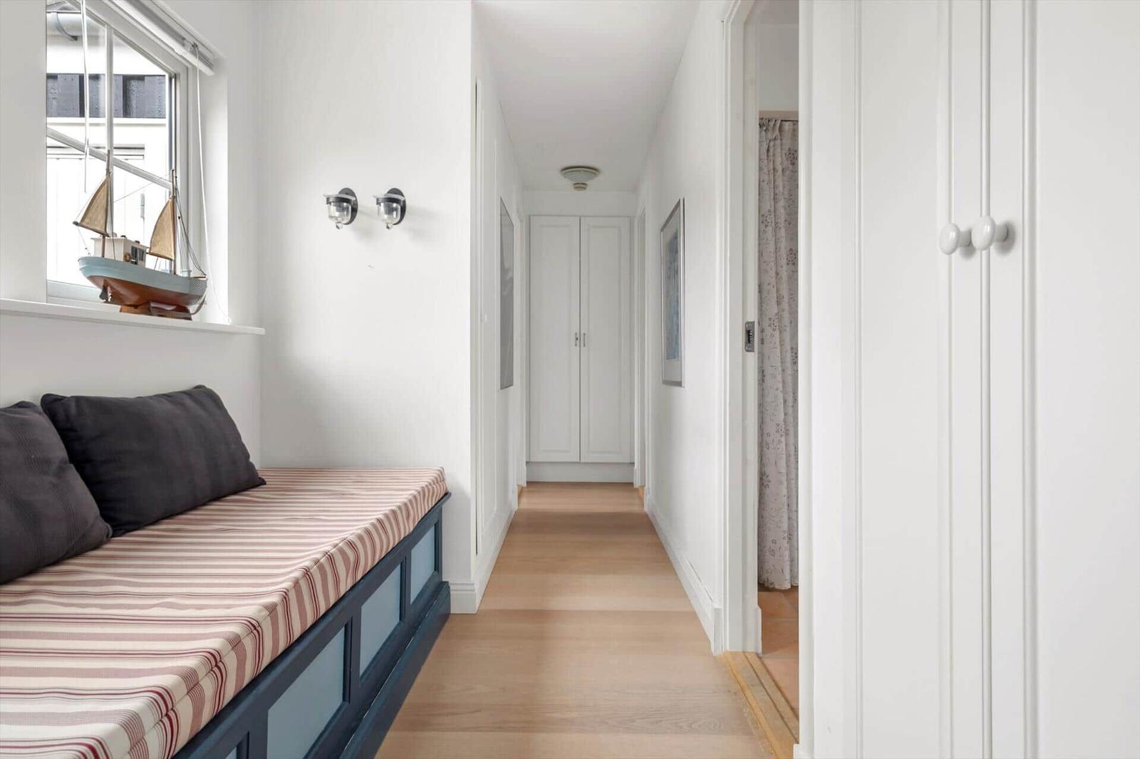 Bedroom with window, sofa and hallway with closet and curtain.