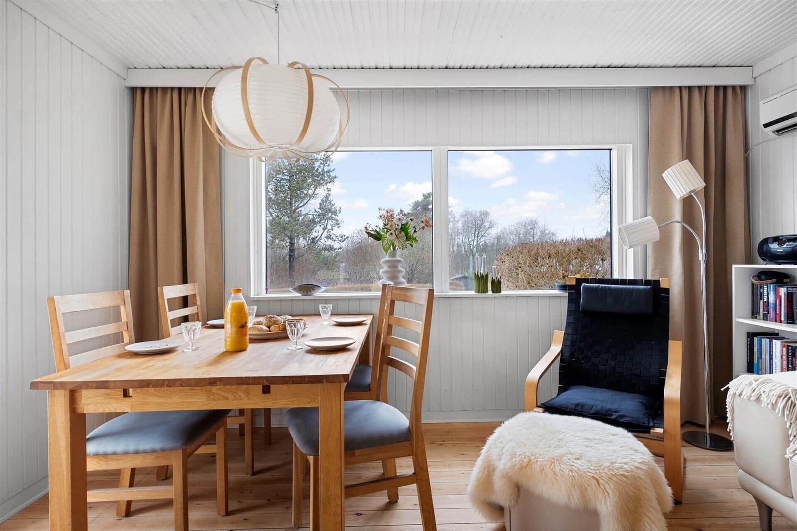 Dining room with wooden table, chairs, and view of outdoor area.