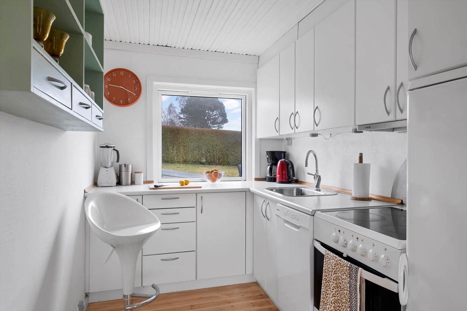 Kitchen with white cabinets, window, and countertop