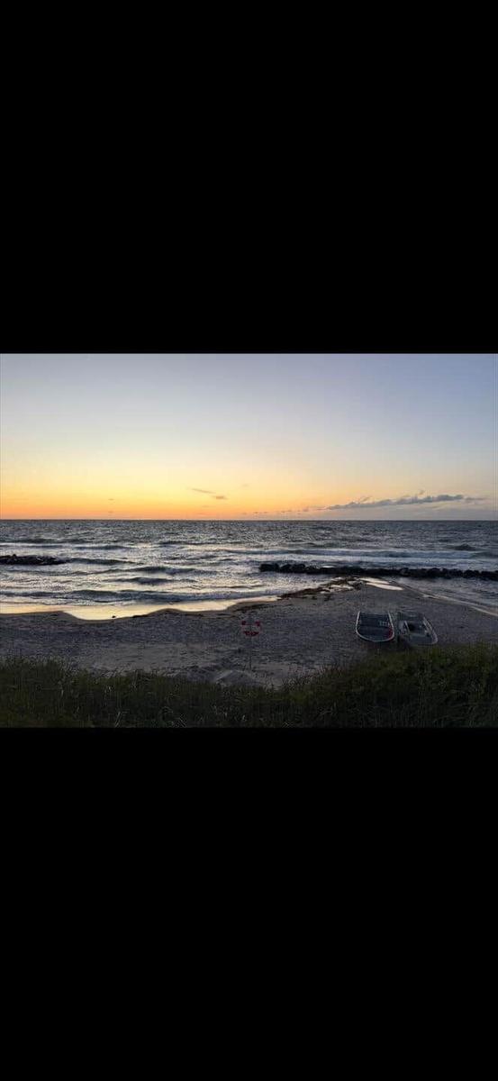 Sunset at the beach with boats and waves