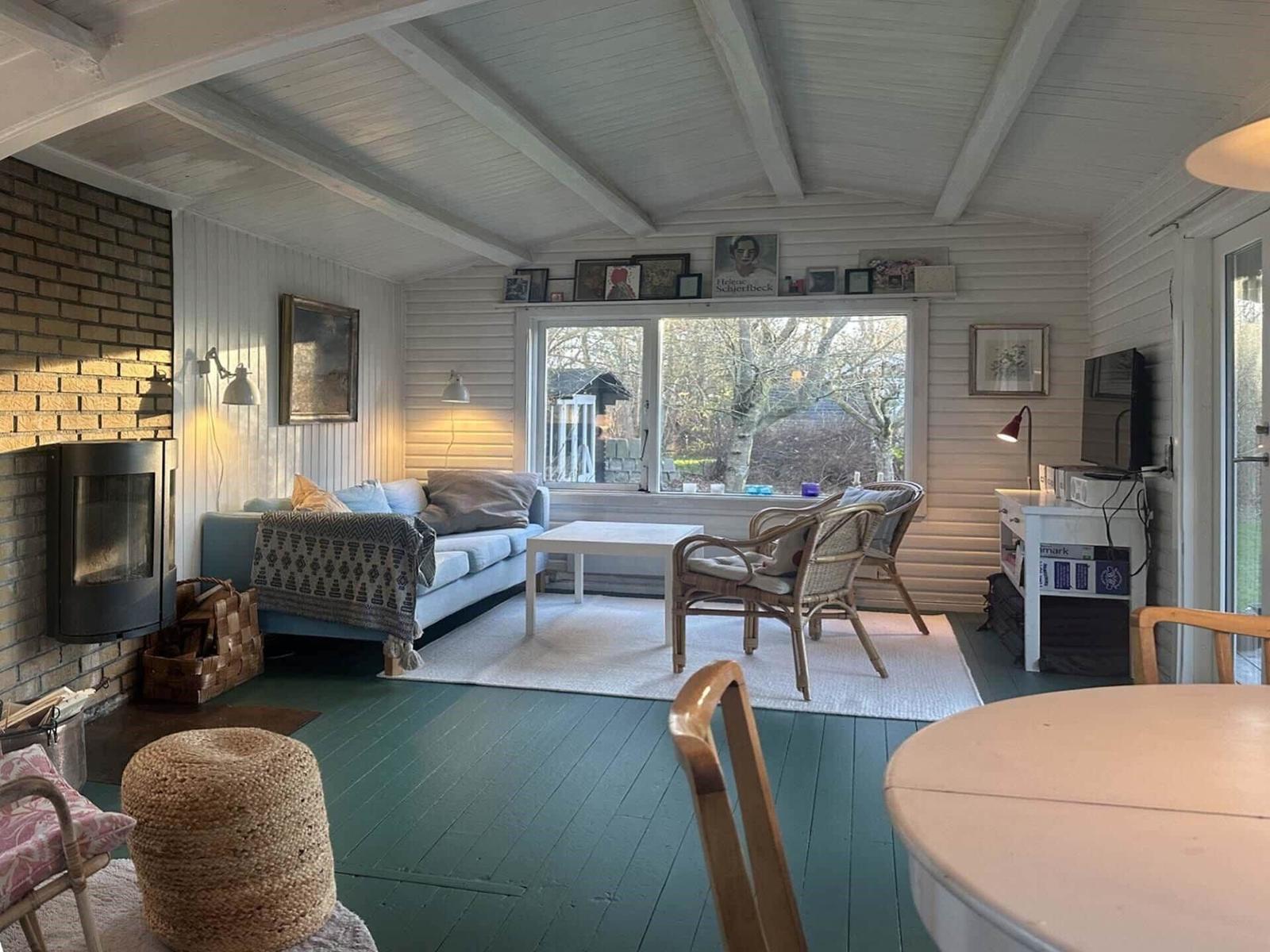 Living room with sofa, seating group, and fireplace. Garden view from window.
