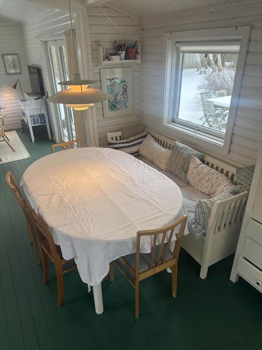 Dining room with round table, wooden chairs, and snowy view