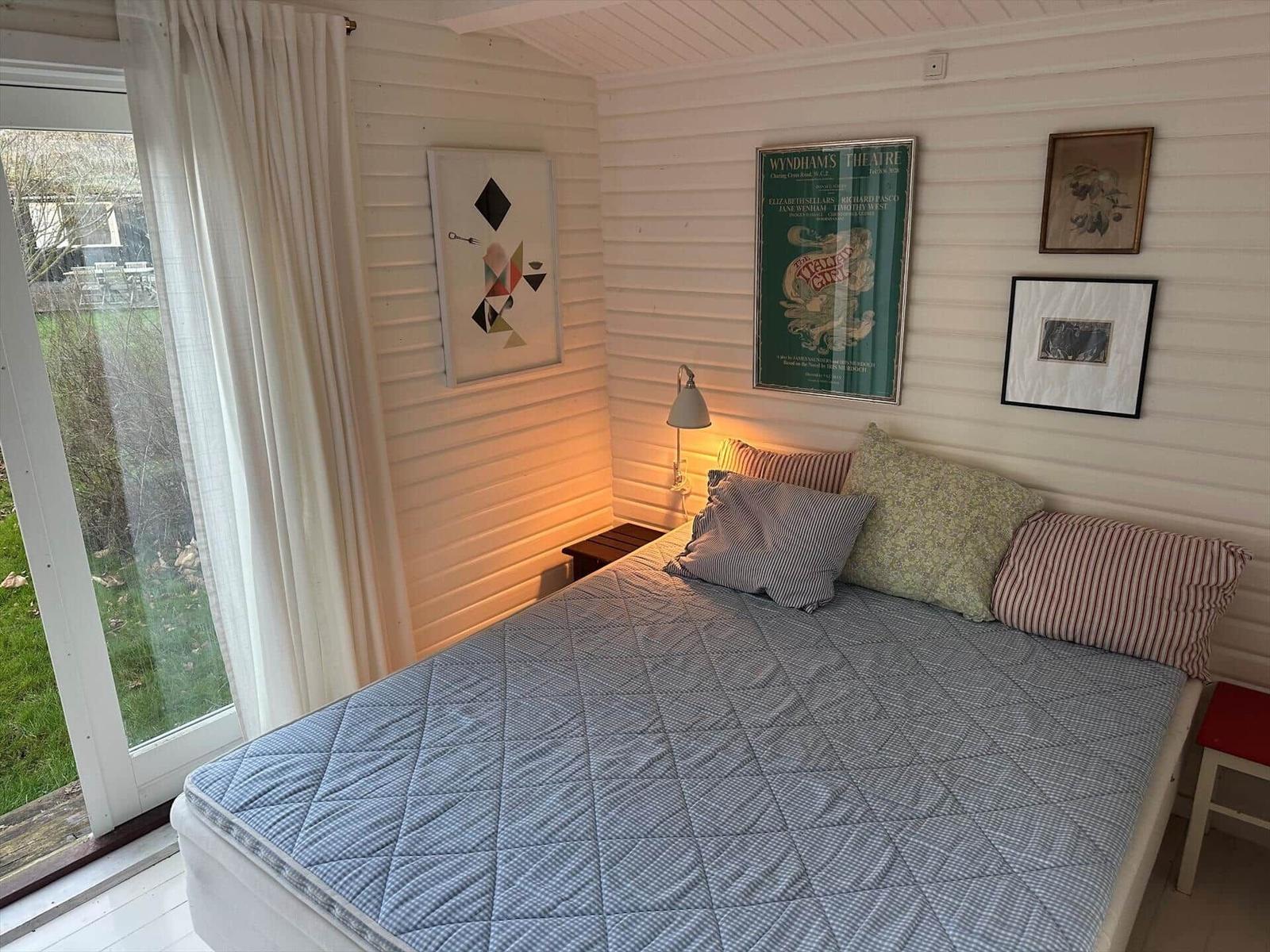 Bedroom with bed, window, and wall art.