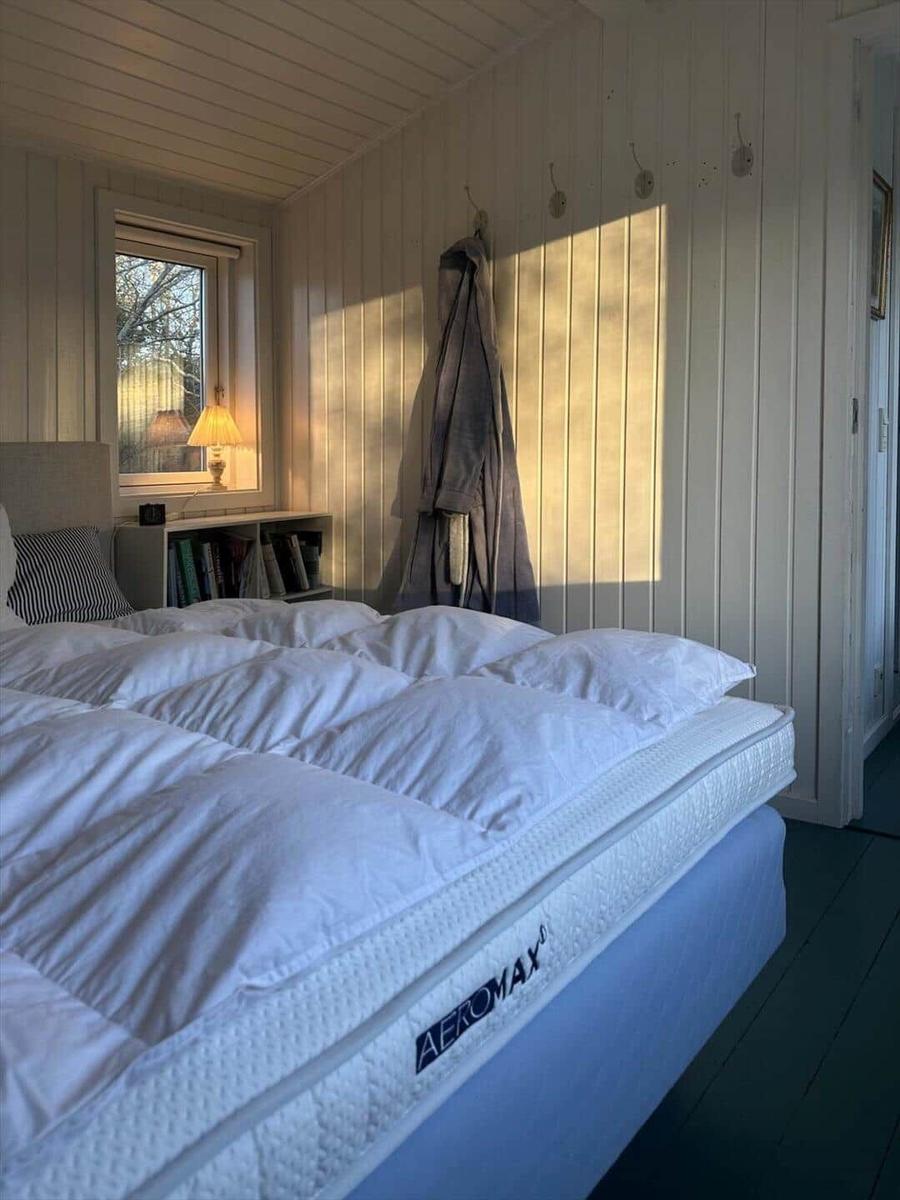 Bedroom with bed, window, and wall hooks.