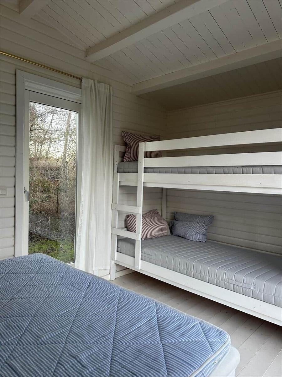 Room with bunk bed and sleeping space near window