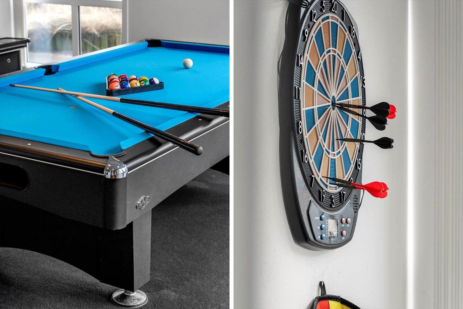 Billardtisch mit Bällen und Stöcken. Dartboard mit eingeklebten Dartpfeilen.