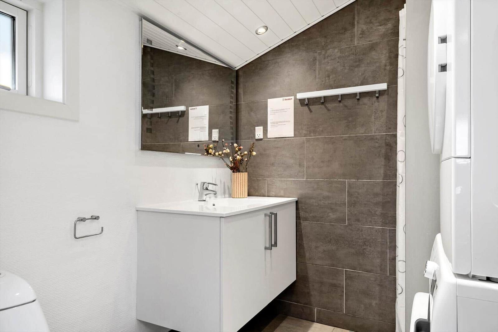 Badezimmer mit Waschbecken, Spiegel und Dusche