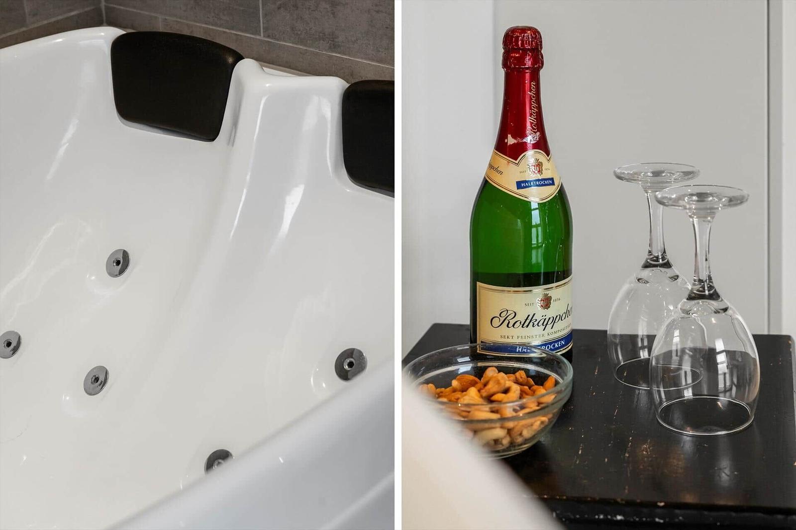 Badewanne mit Massagefunktion und Sekt mit Gläsern und Nüssen.