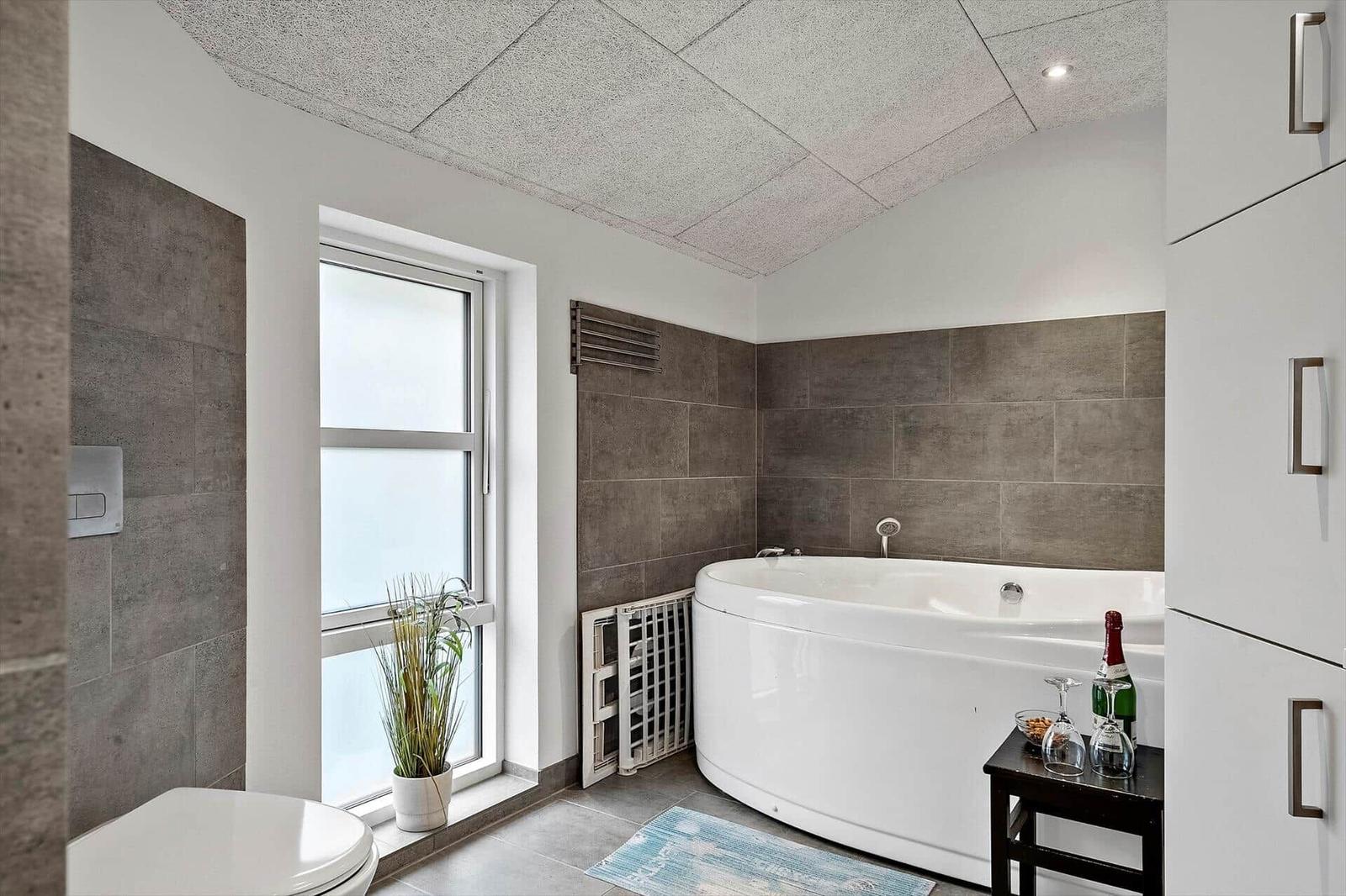 Badezimmer mit Badewanne, Fenster und Toilette