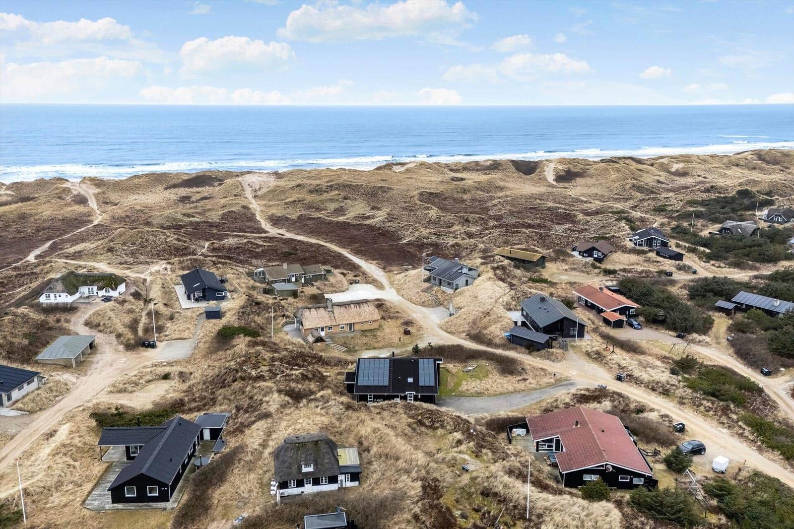 Meerblick von Dünen mit mehreren Häusern und Pfaden