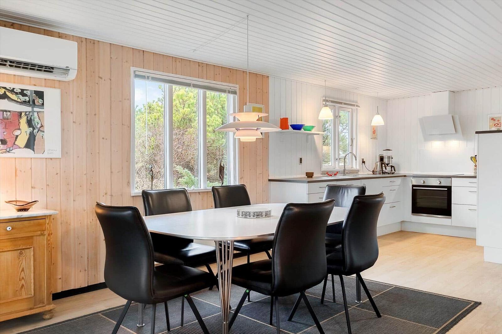 Essbereich mit Tisch und Stühlen, Küche mit Arbeitsplatten und Fenster