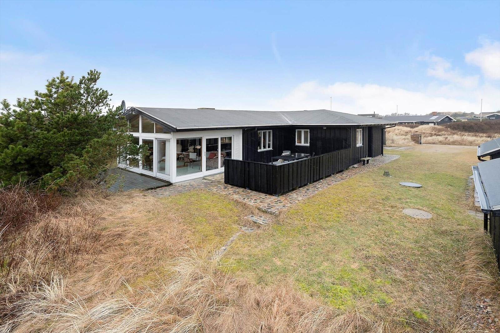 Moderne Villa mit großem Glasbereich und Terrasse im Grasland.