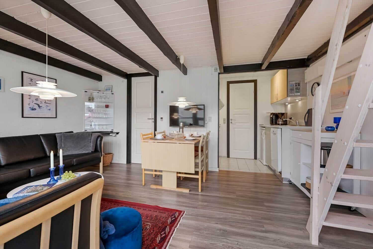 Wohnzimmer mit Essbereich, Küche und Treppe zur oberen Etage.