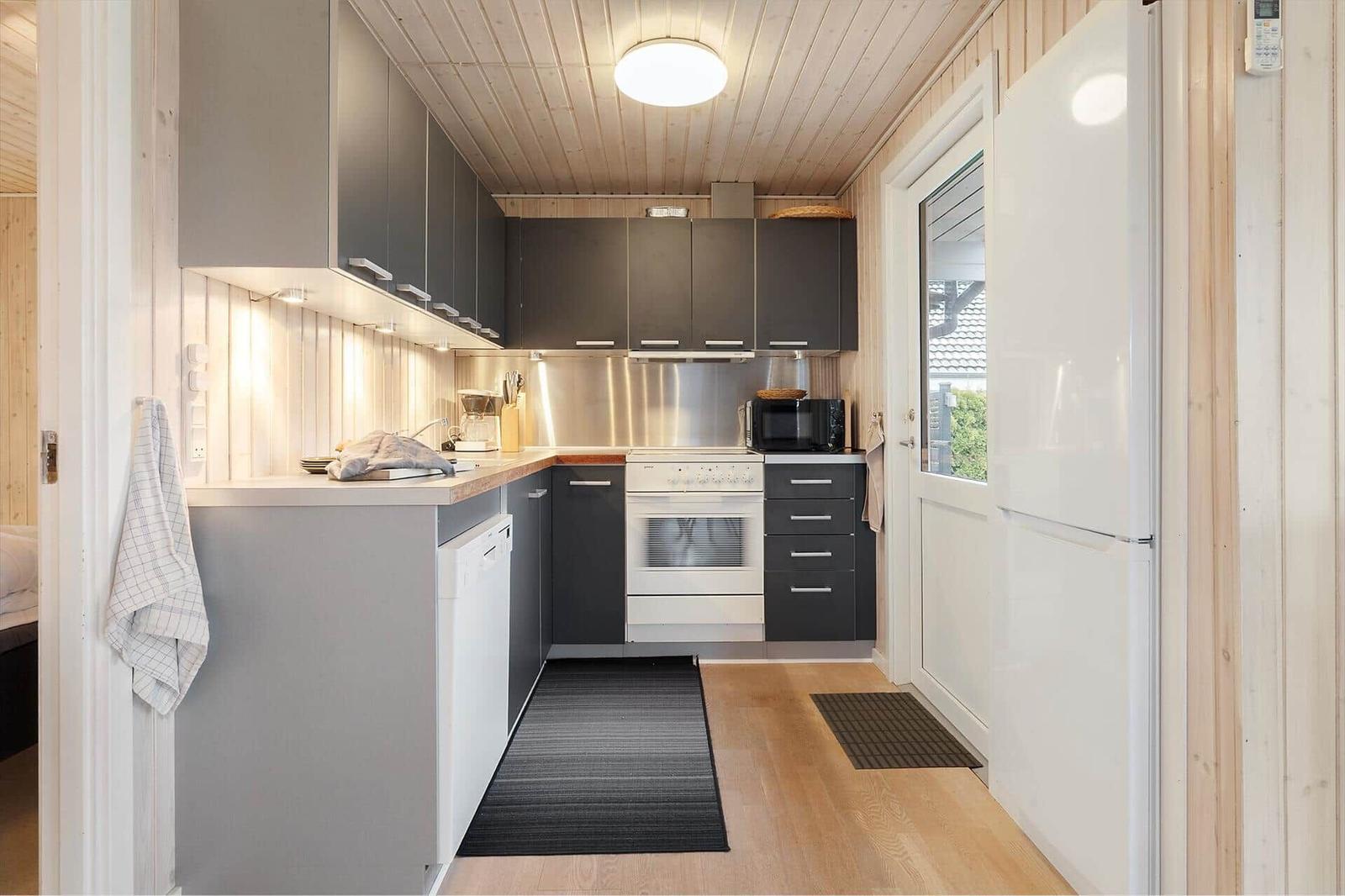 Kitchen with dark cabinets, white sink, and kitchen counter
