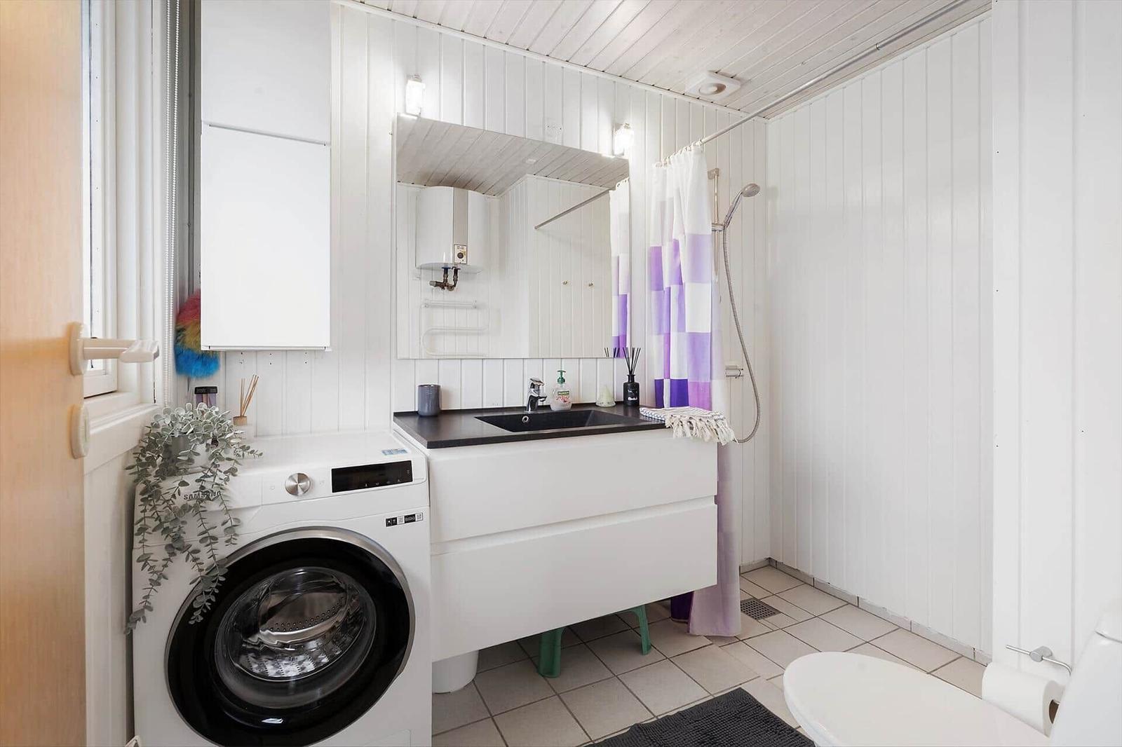 Bathroom with washing machine, shower, and mirror