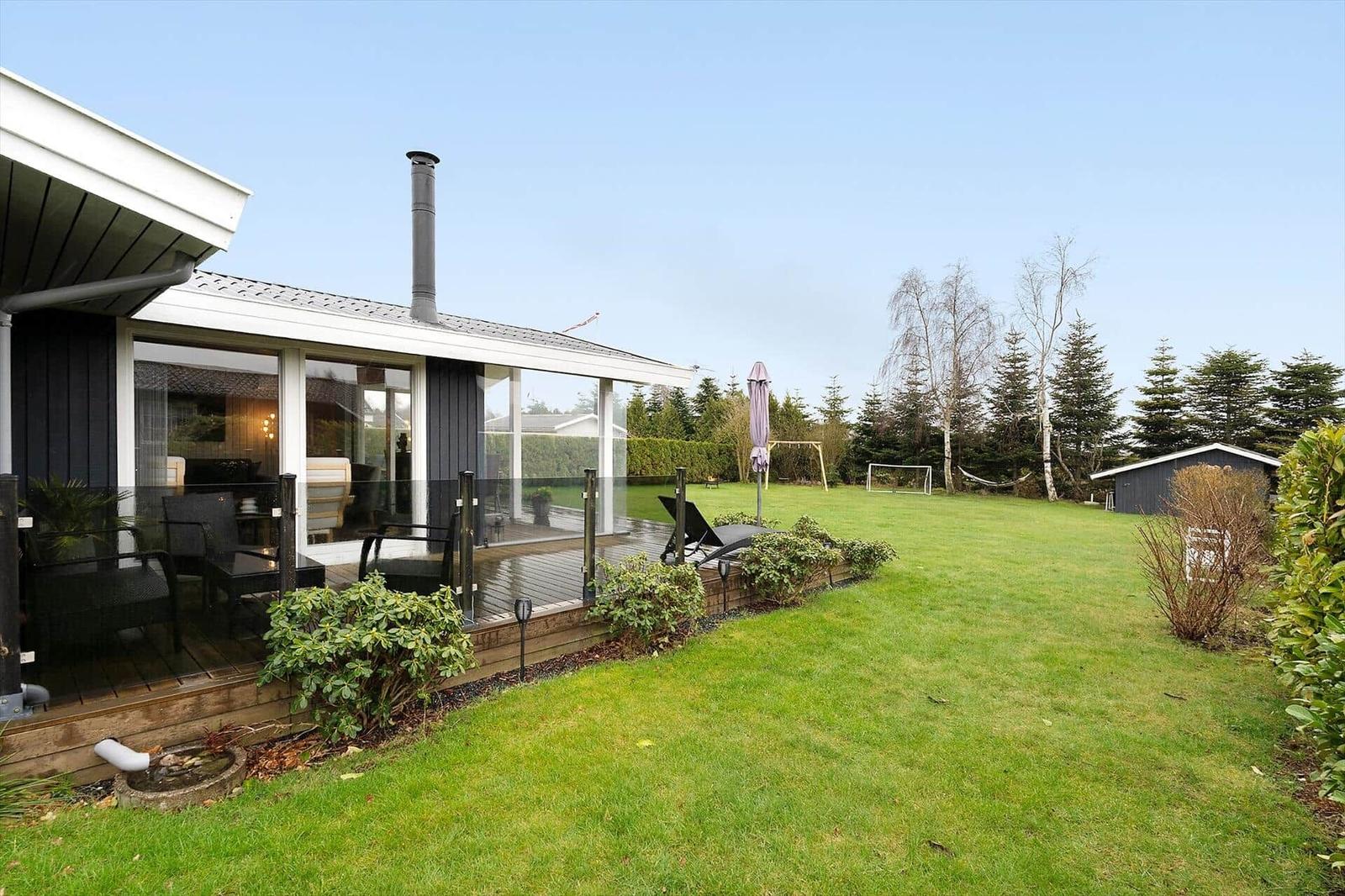 Modern villa with terrace, garden, and barbecue area.