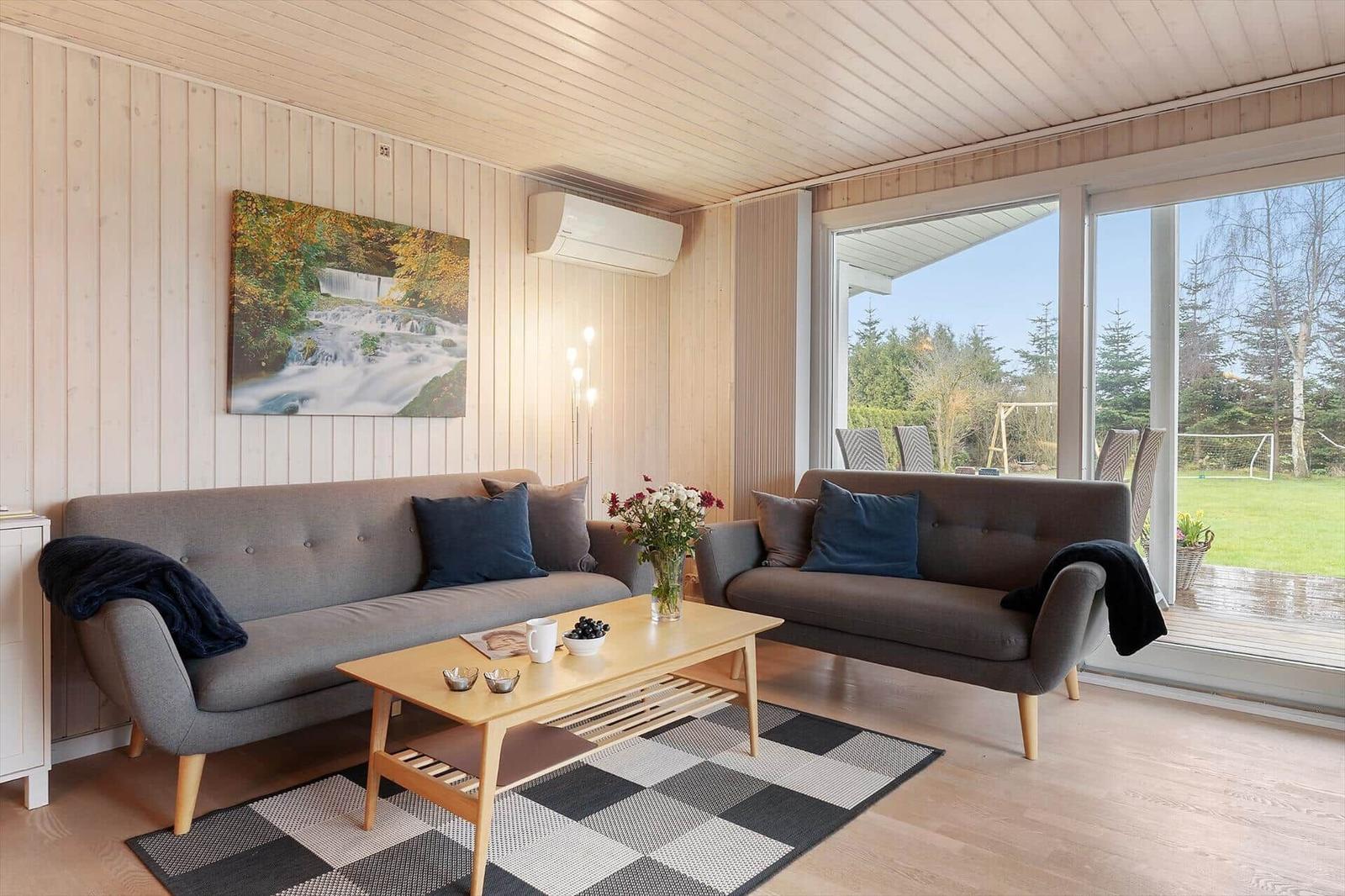 Living room with two sofas, table, and view of garden.