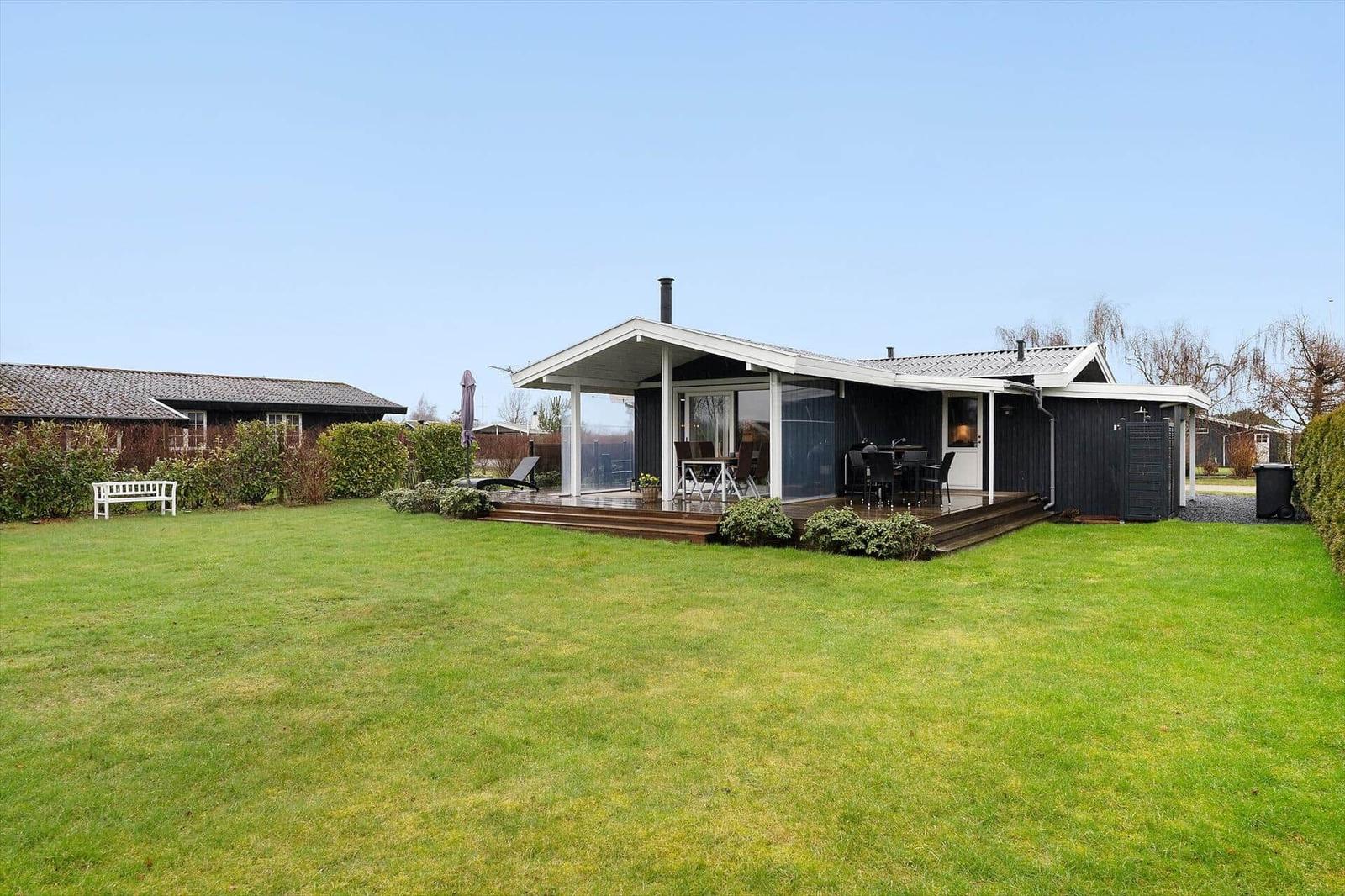 Modern villa with terrace, garden, and seating areas.