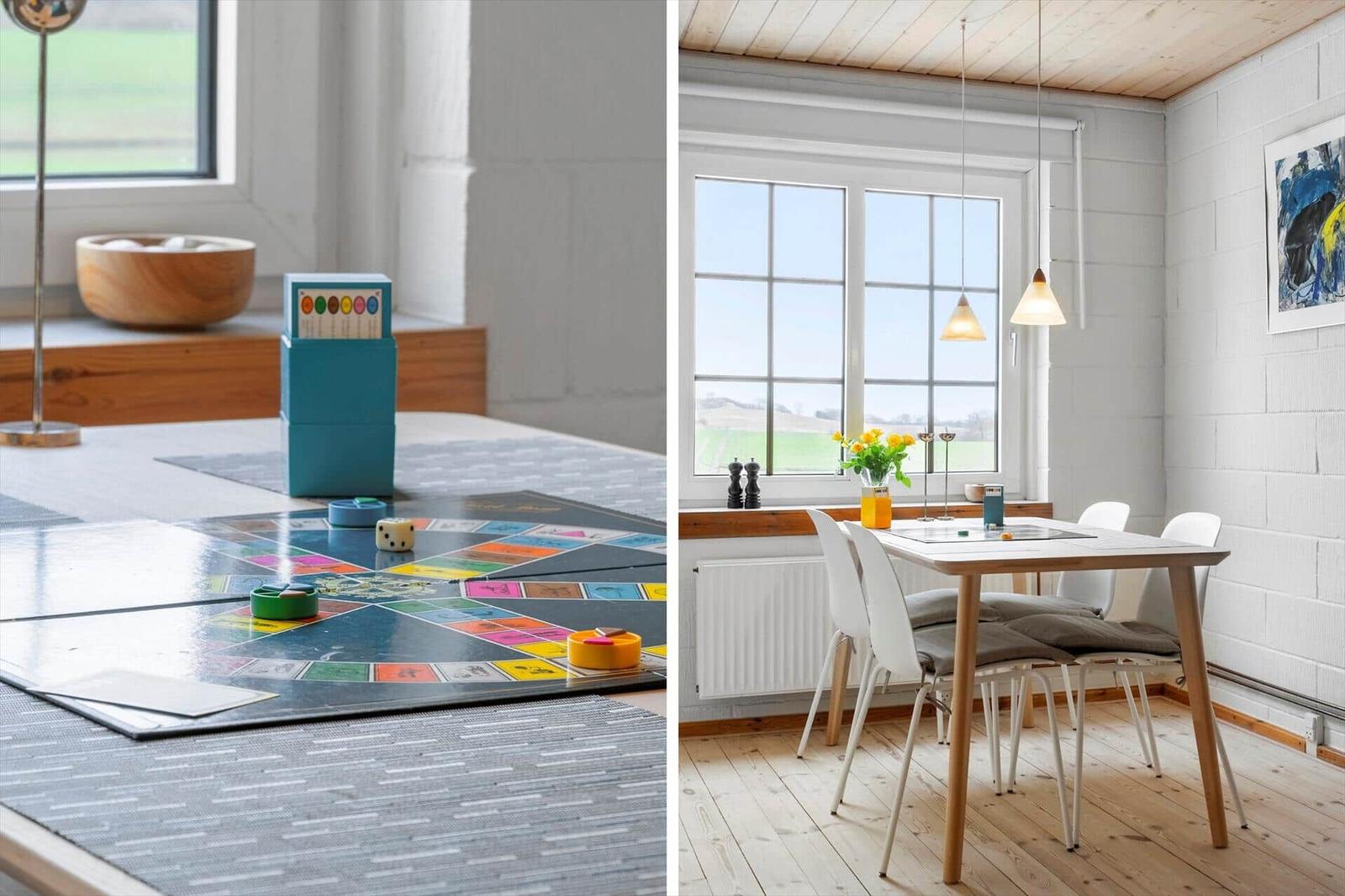 Tisch mit Brettspiel und Fensterblick. Essbereich mit Tisch, Stühlen und Fenster.